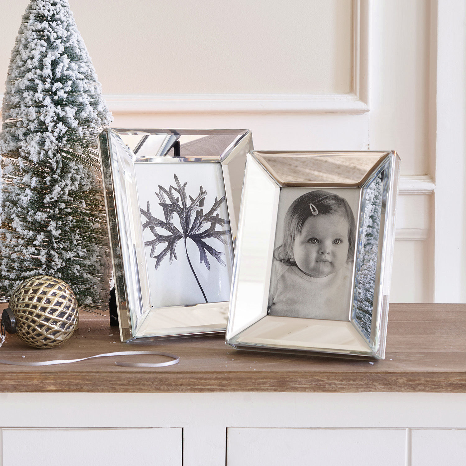Bilderrahmen 2er Set Dominique Zwei verspiegelte Bilderrahmen auf Holzplatte mit Weihnachtsdekoration und schneebedecktem Tannenbaum