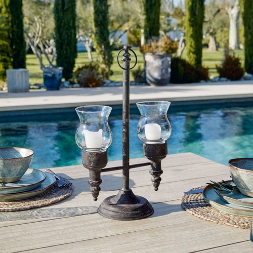 Metall-Kerzenhalter mit zwei Glashüllen für Kerzen, draussen am Pool auf dem Holztisch