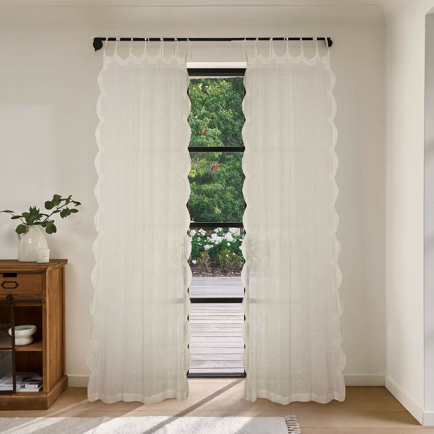 Gardine Dolcin Transparente weisse Gardinen mit wellenförmigem Rand in hellem Raum mit Gartenblick
