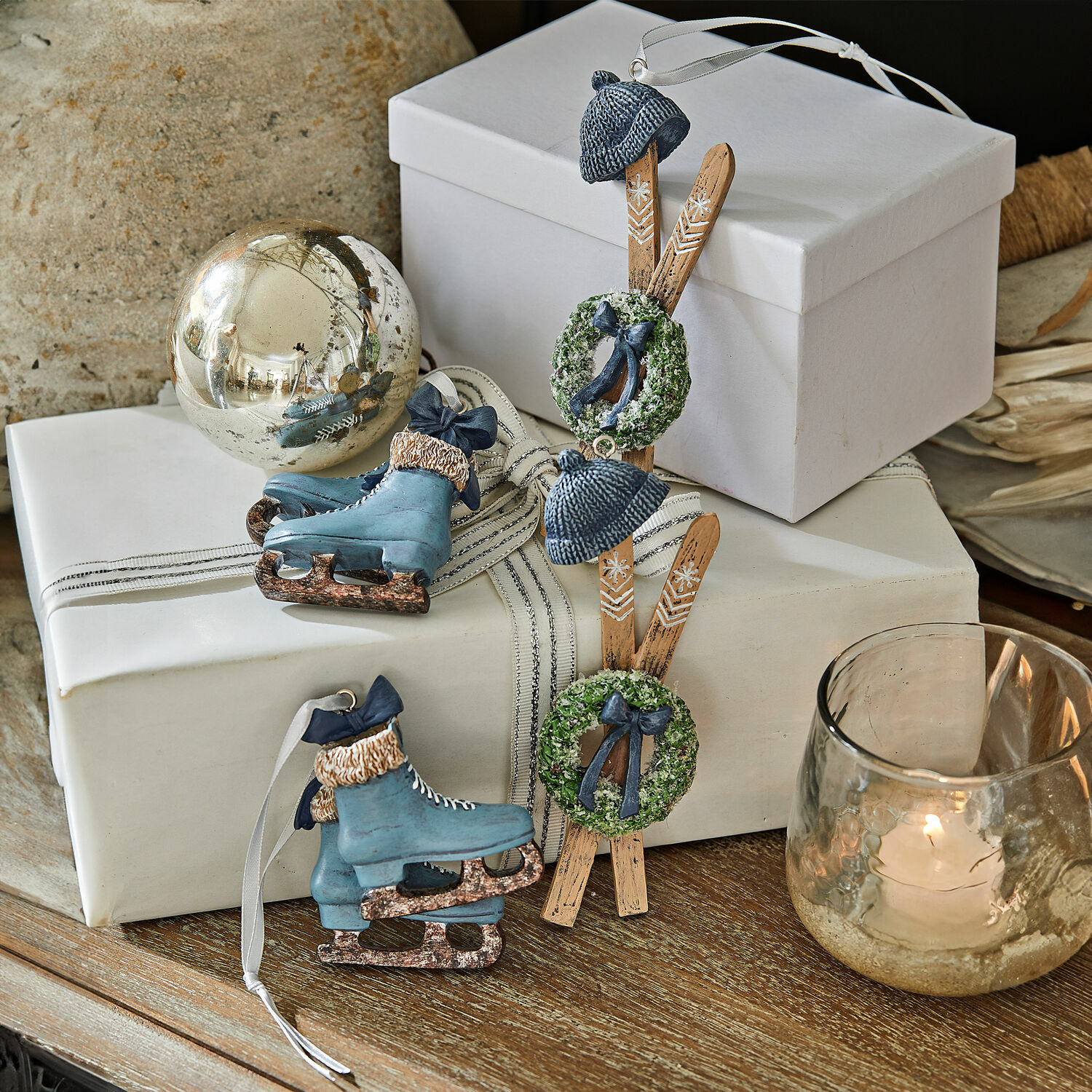 Anhänger 4er Set Papeta Weihnachtsdekoration mit blauen Schlittschuhen und Holzskiern mit grünen Kränzen auf einem Holztisch