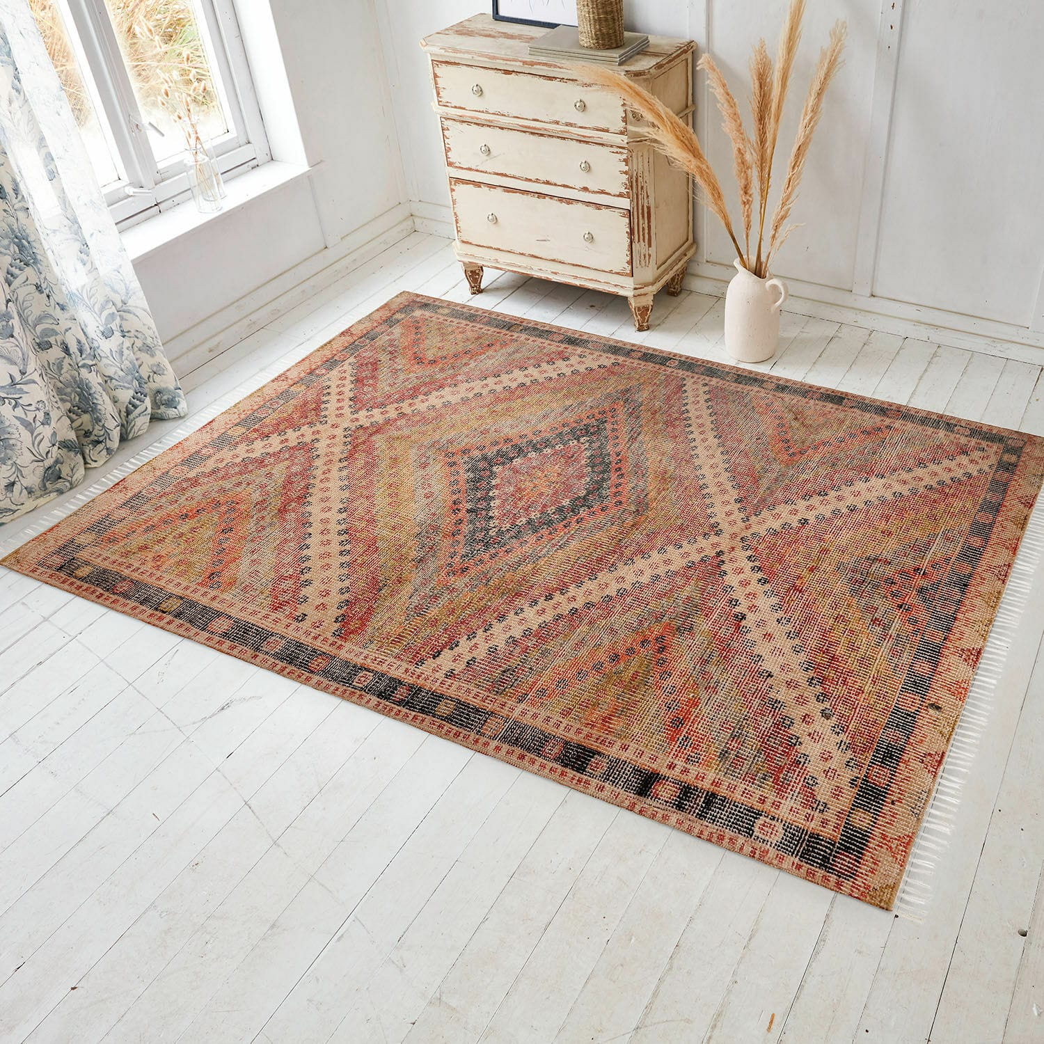 In- & Outdoor-Teppich Mildura Teppich mit geometrischem Muster in warmen Rot- und Beigetönen auf hellem Holzboden