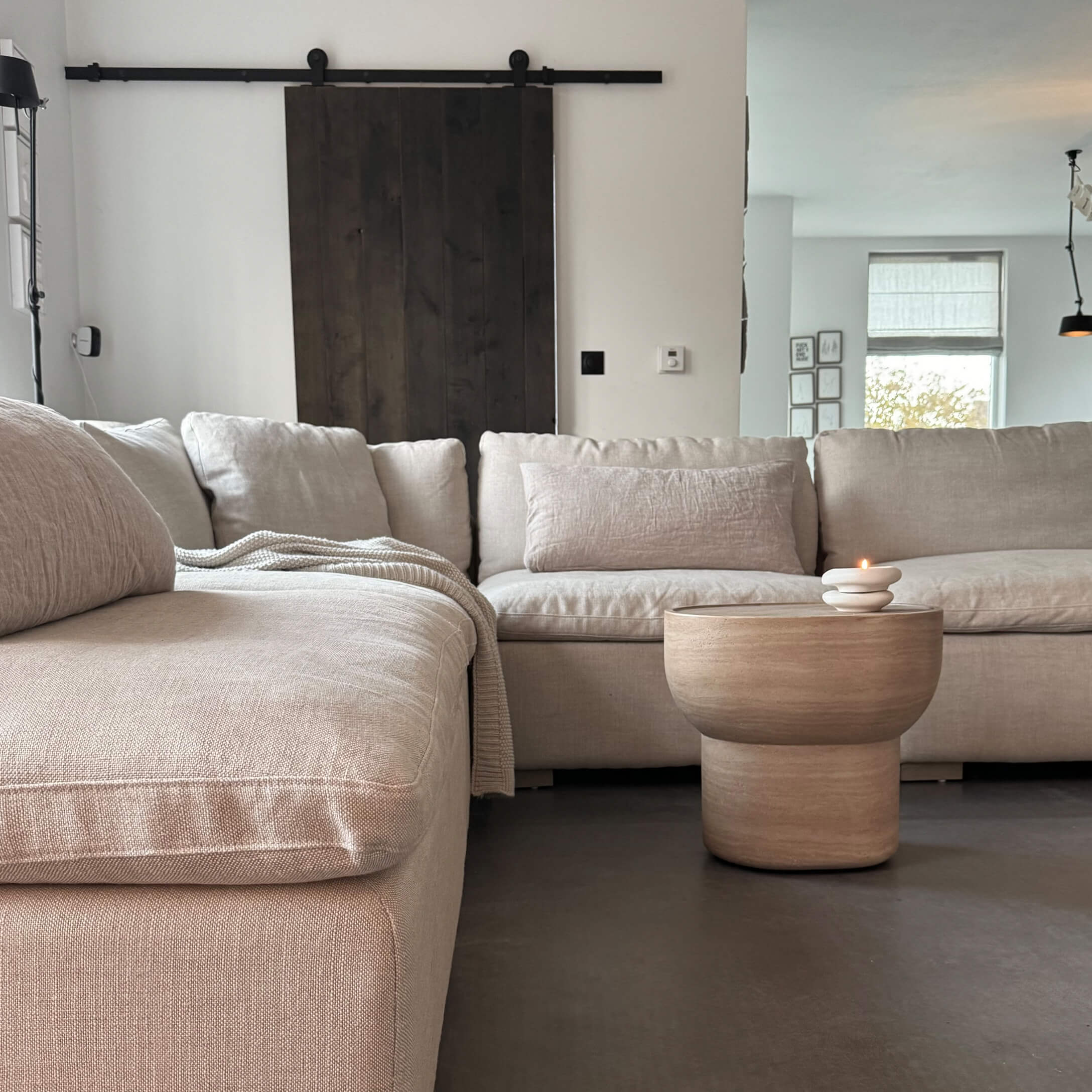 Beige Ecksofa aus Stoff mit Holztisch und Kerze in modernem Wohnzimmer