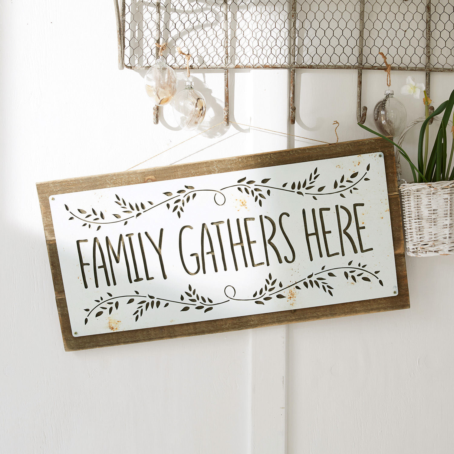 Dekoratives Wandschild aus Holz und weissem Metall mit Schriftzug Family Gathers Here
