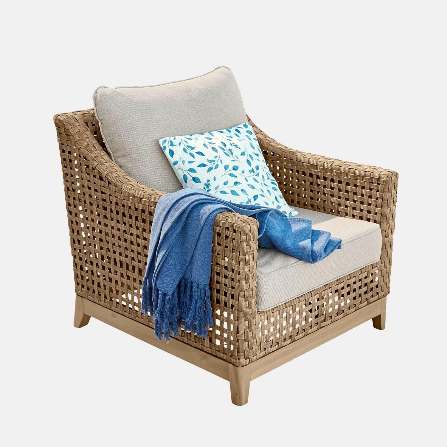 Geflochtener Rattansessel mit beigem Kissen und blauem Plaid, bequemer Wohnzimmerstuhl