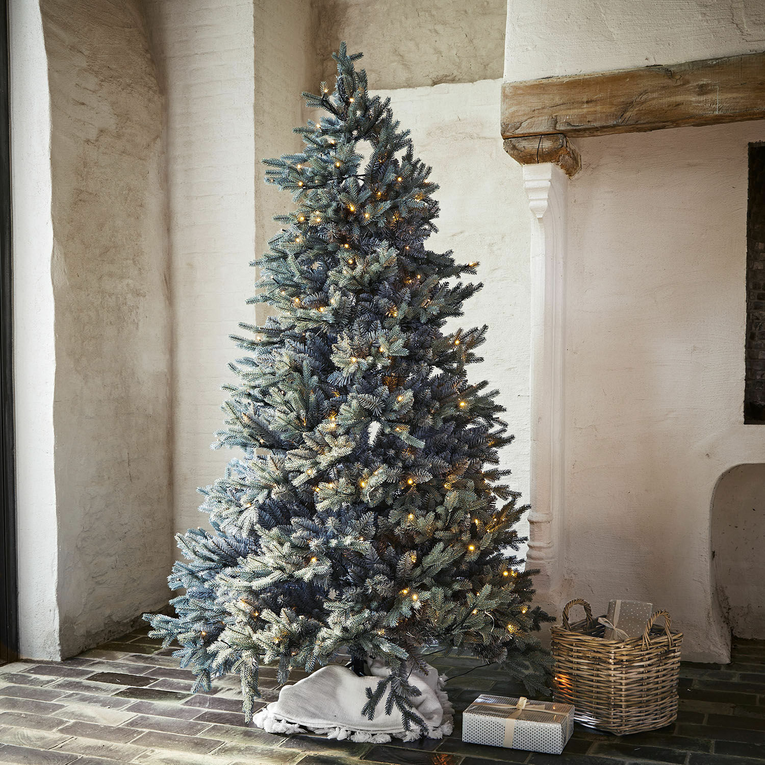 Weihnachtsbaum Patrick Künstlicher Weihnachtsbaum mit schneebedeckten Zweigen und warmen LED-Lichtern in rustikalem Raum