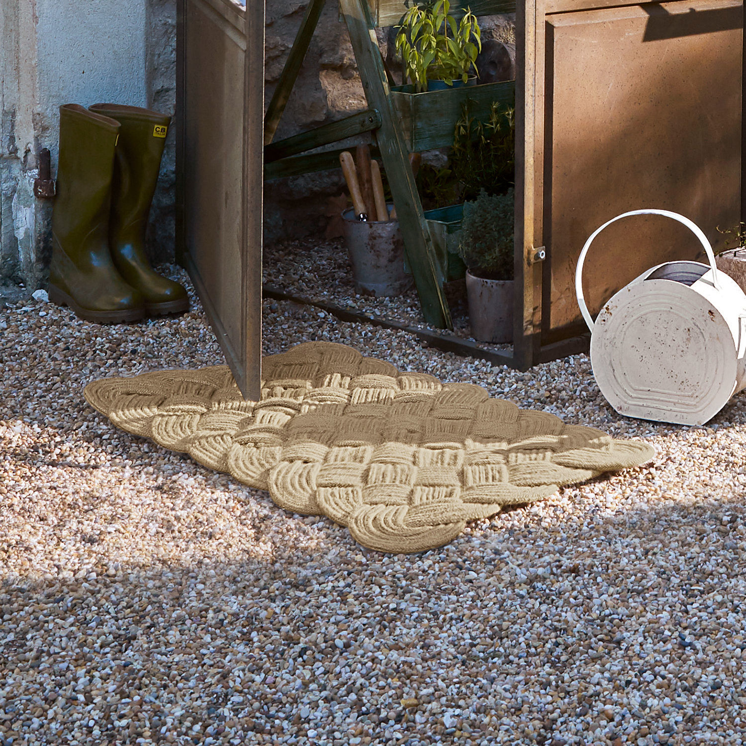Fussmatte Harman Beige gewebte Fussmatte aus Naturmaterial auf Kiesboden vor offener Gartentür