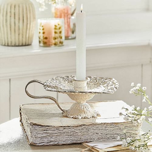 Vintage Metall-Kerzenhalter in Creme auf weissem Buch, Tischdekoration mit weissen Blumen