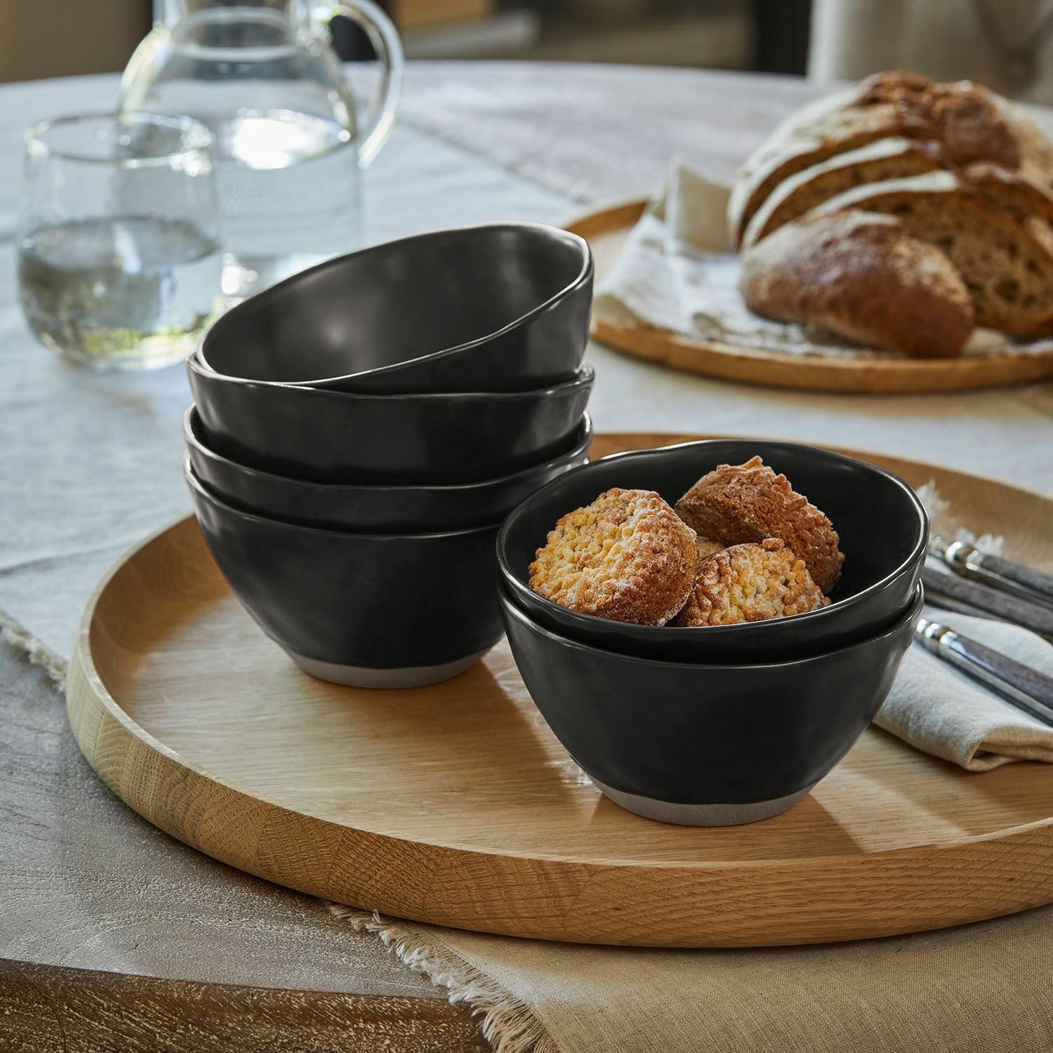 Schüssel 6er Set Biarré Set aus schwarzen Keramikschalen mit naturfarbenem Boden auf Holztablett mit grünen Birnen