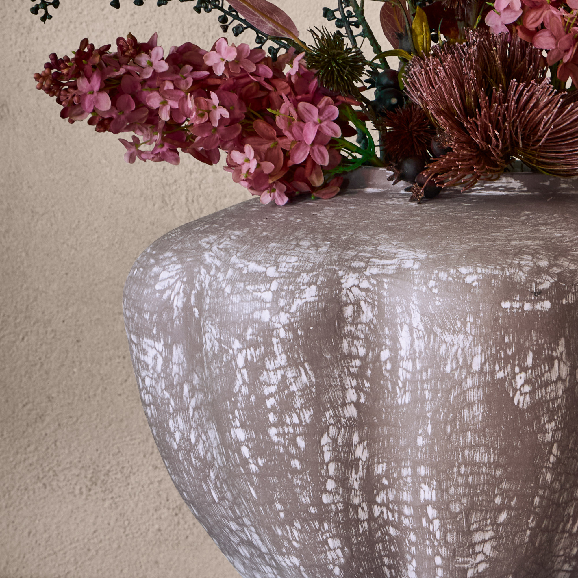 Dekorativer grauer Keramikvase mit weißem Muster und rosa künstlichem Blumenstrauß