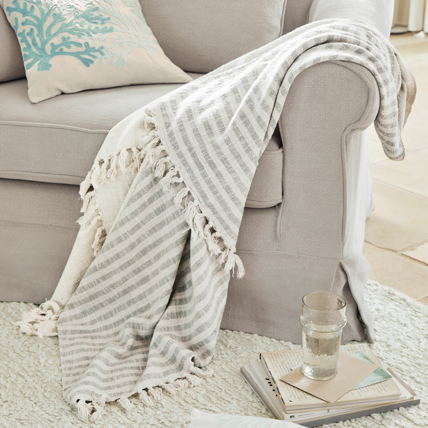 Plaid Marpent Beige gestreifte Kuscheldecke mit Fransen auf hellgrauem Sofa, gemütliches Wohnaccessoire