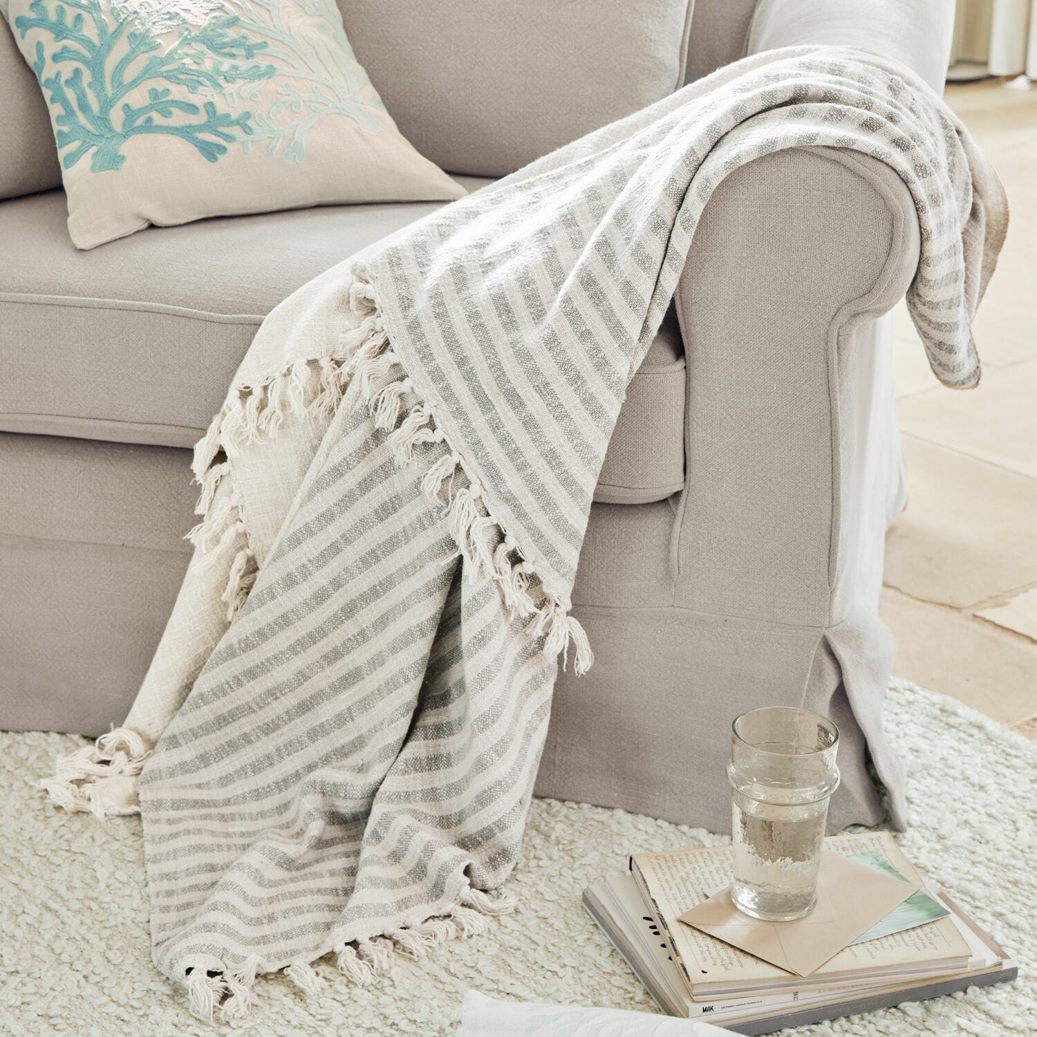 Plaid Marpent Beige gestreifte Kuscheldecke mit Fransen auf hellgrauem Sofa, gemütliches Wohnaccessoire