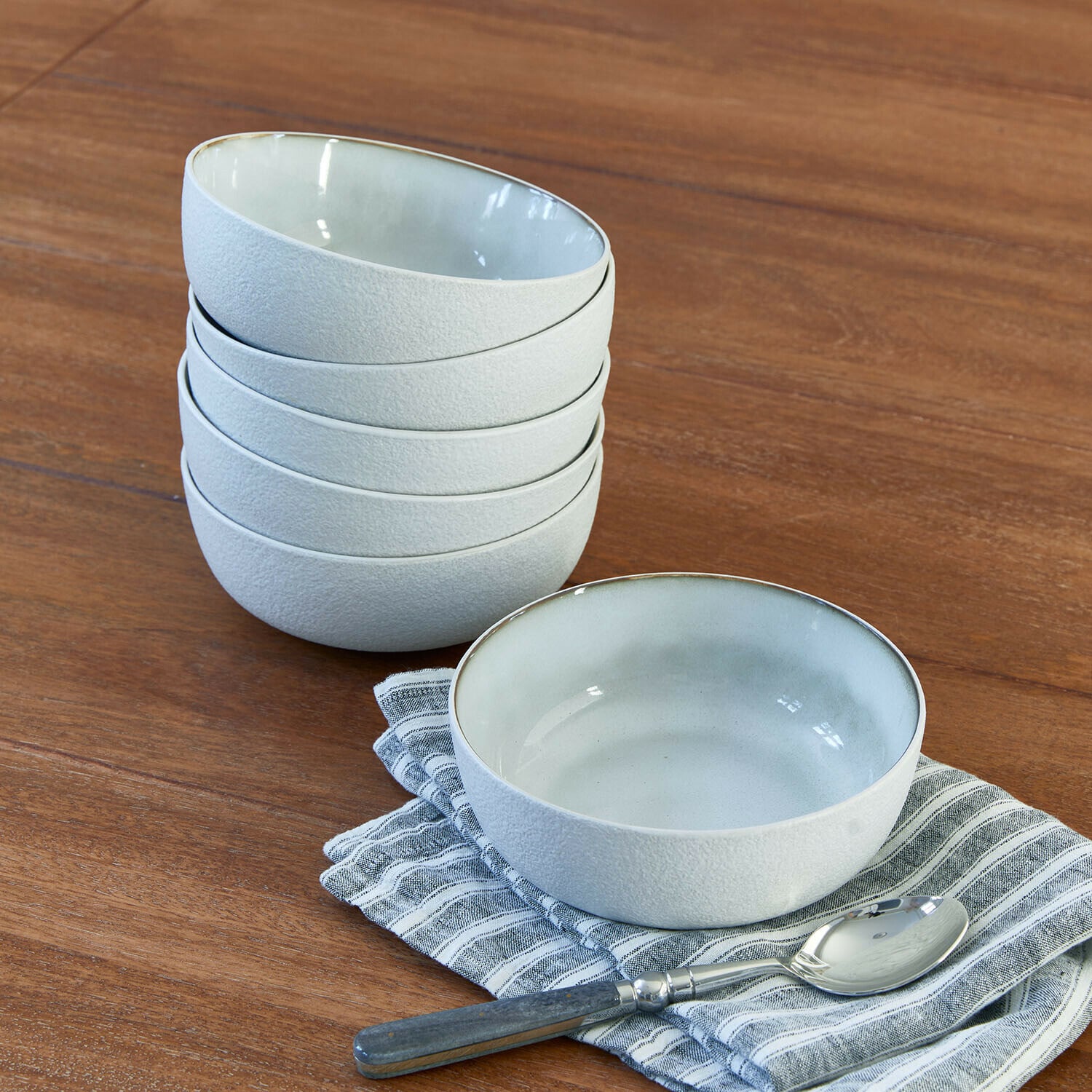 Schüssel 6er Set Eiruna Set weiße Keramikschalen mit matter Oberfläche auf Holztisch mit Löffel und Stoffserviette
