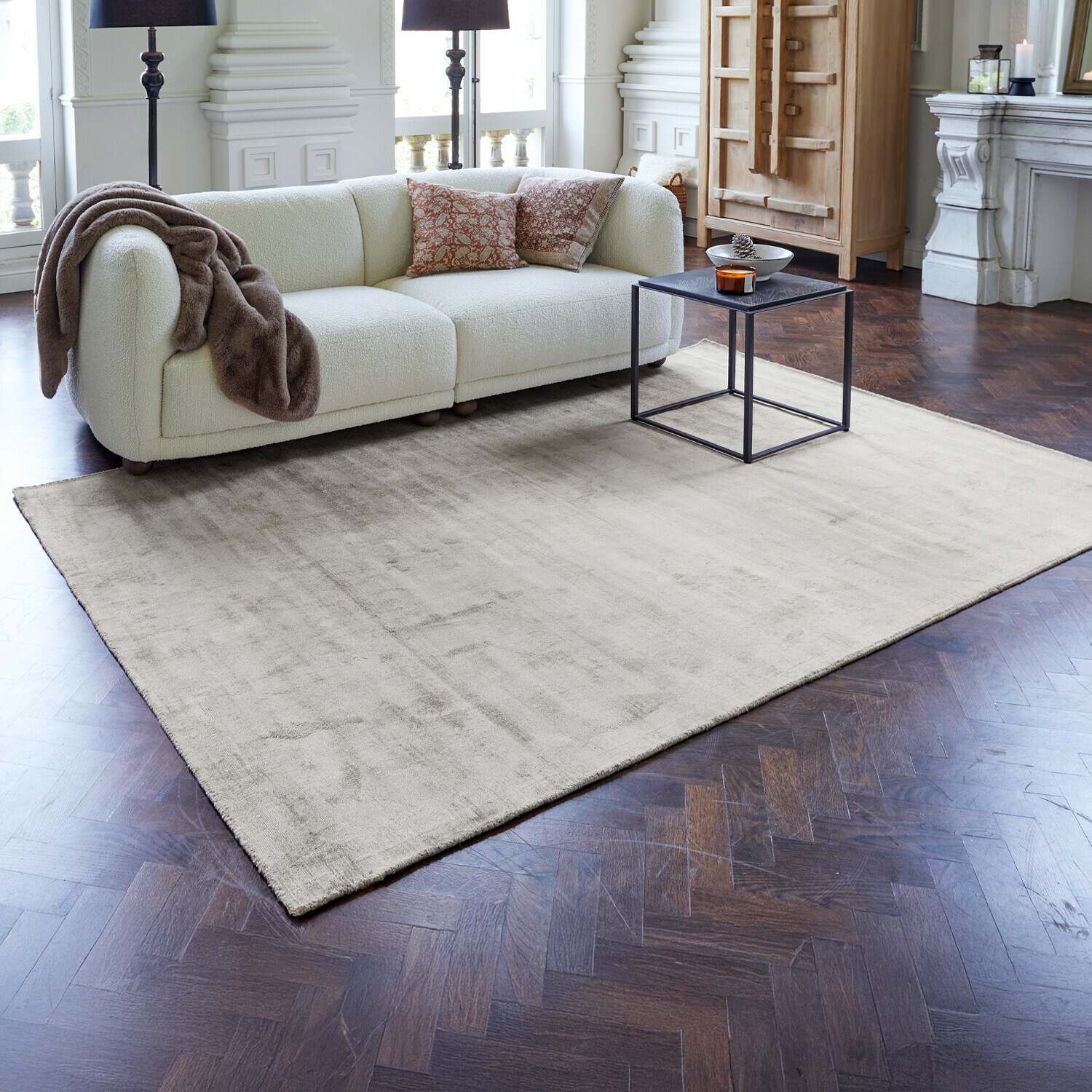 Teppich Mariselle Beigefarbener Teppich aus weichem Material auf dunklem Holzboden im modernen Wohnzimmer mit weissem Sofa
