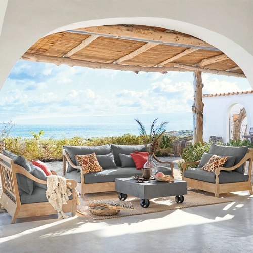 Gartenmöbel-Set aus Holz mit grauen Polstern auf der Terrasse mit Meerblick, komfortable Lounge-Möbel