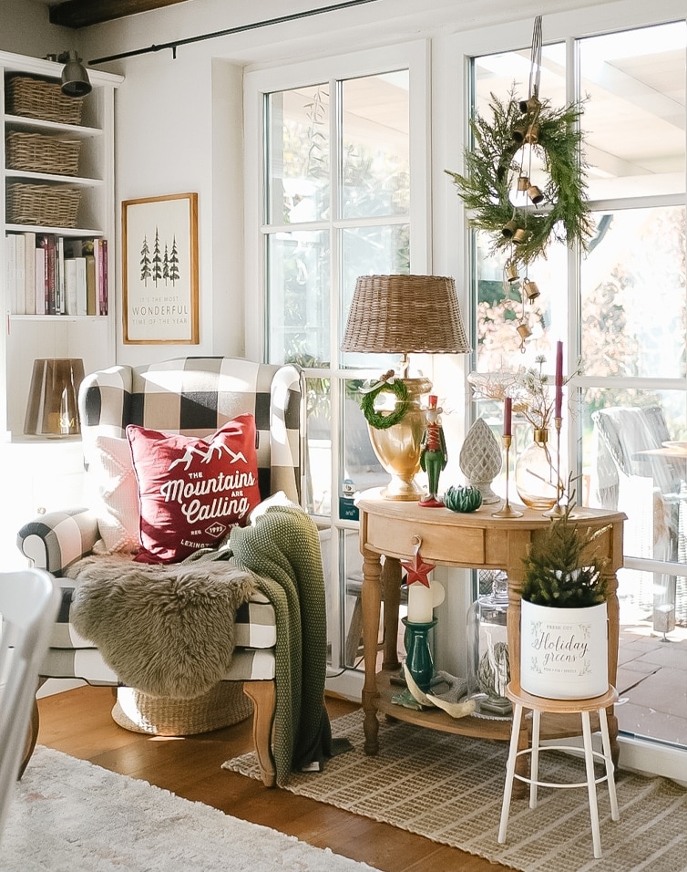 Gemütliche Ecke mit kariertem Sessel, Weihnachtsdekoration und Lampe auf Holztisch im Wohnzimmer.