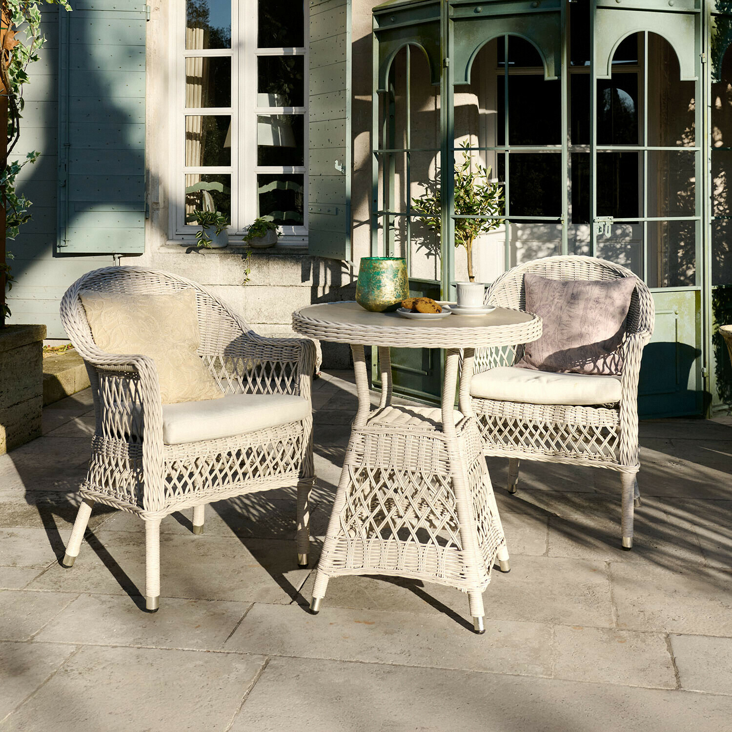 Sitzgruppe Solavine Weisses Rattan-Gartenmöbel-Set mit Kissen, runder Tisch und zwei Sesseln auf Terrasse
