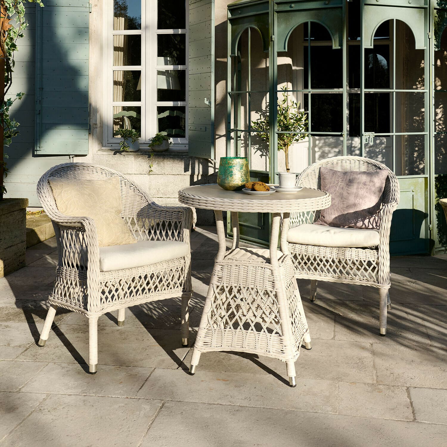 Sitzgruppe Solavine Weisses Rattan-Gartenmöbel-Set mit Kissen, runder Tisch und zwei Sesseln auf Terrasse