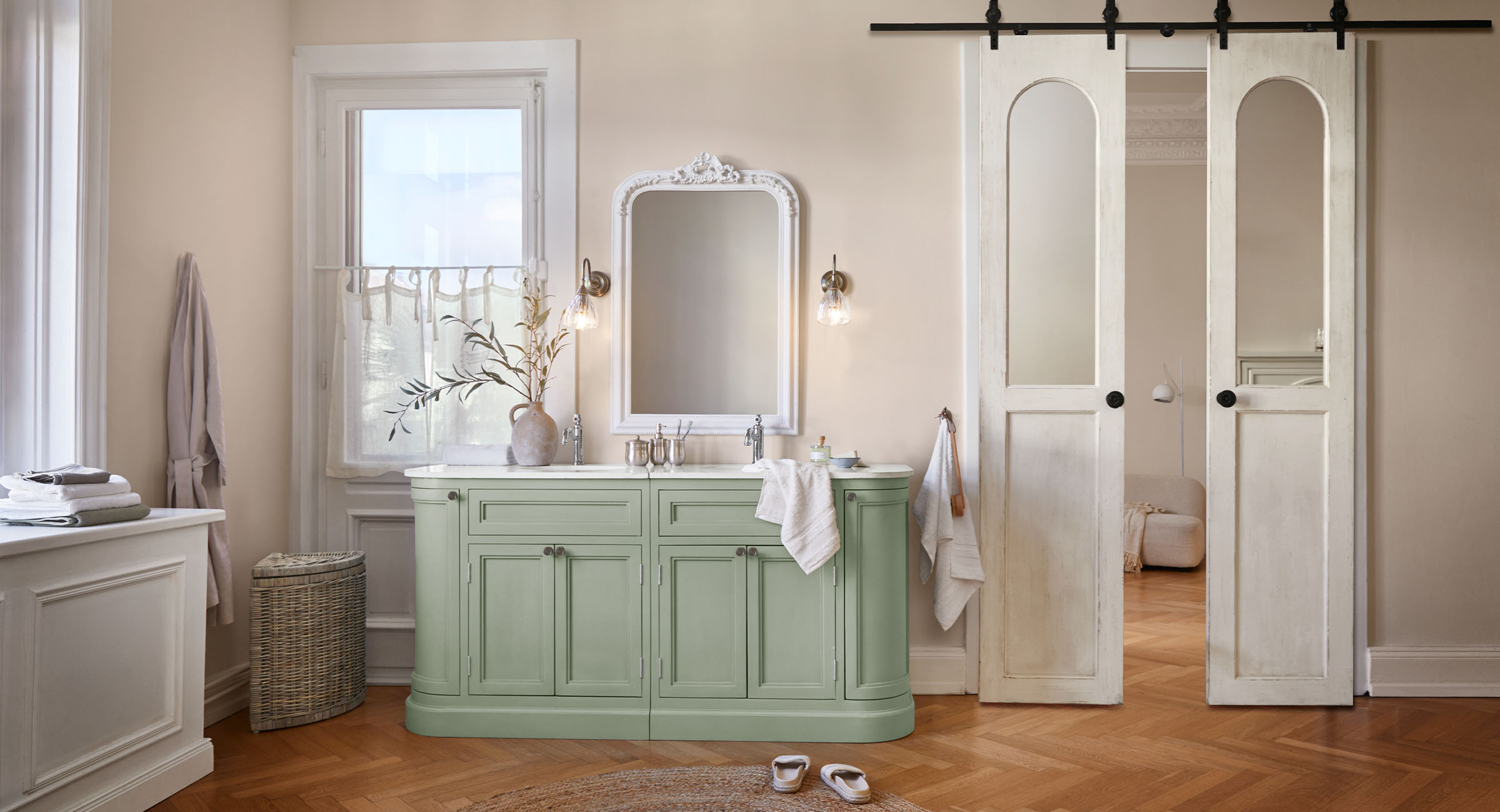Badezimmer mit grünem Holzschrank, weiss gerahmtem Spiegel und hellen Wänden im Vintage-Stil