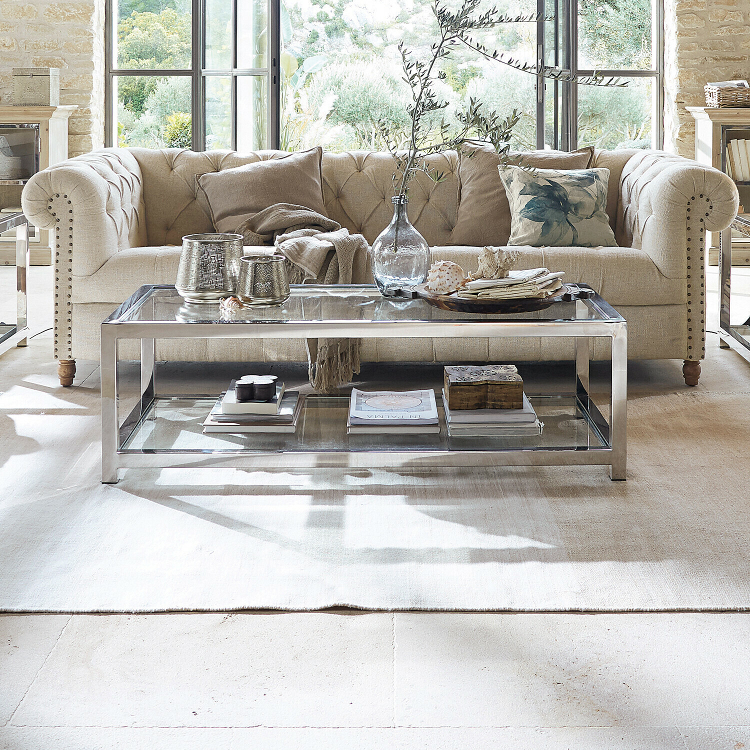 Couchtisch Clayton Moderner Couchtisch aus Glas und silbernem Metall im hellen Wohnzimmer mit beigem Sofa