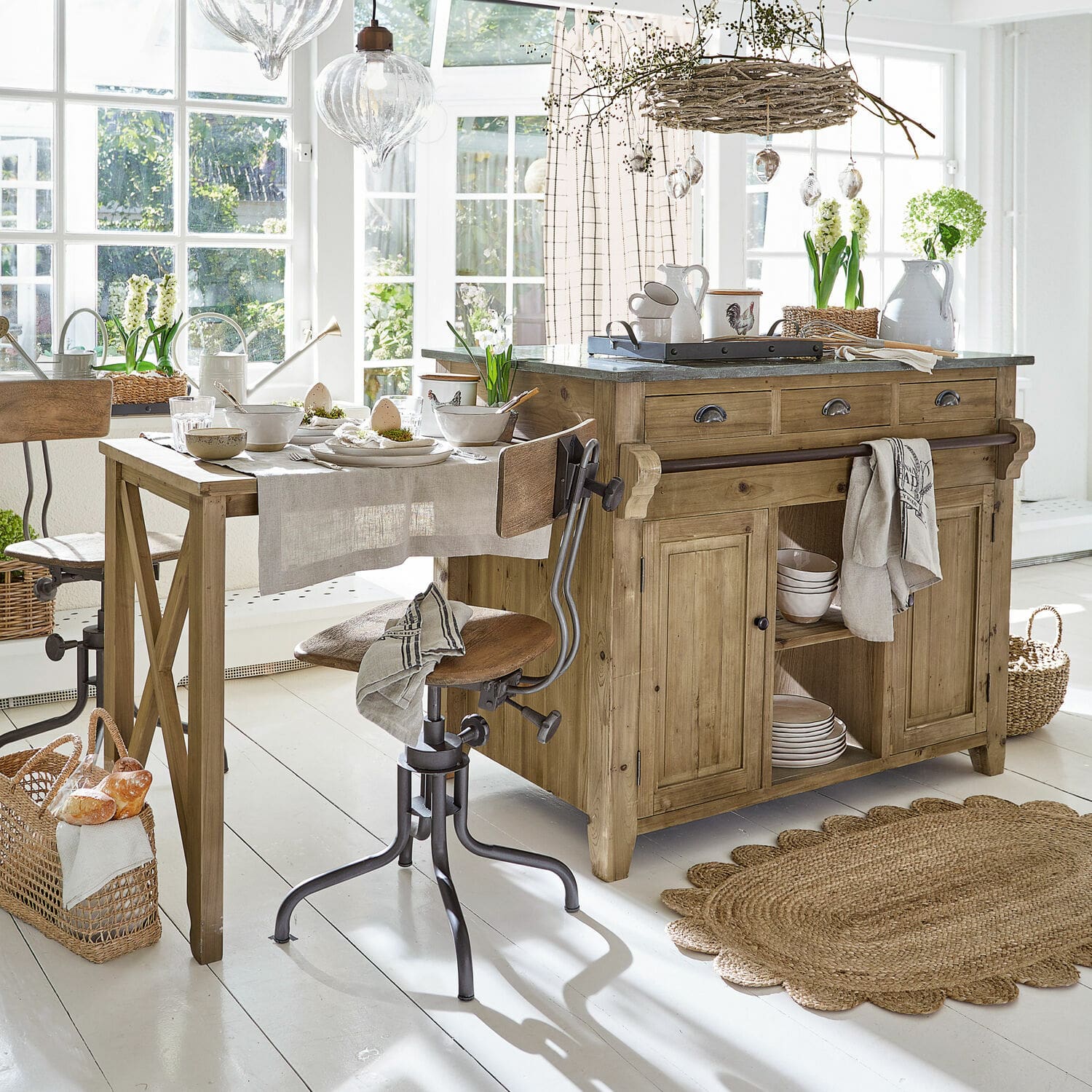 Küchenblock Évain Rustikale Küche mit Holzinsel und Tisch, natürliche Materialien und helle Dekorationen in sonnigem Raum.