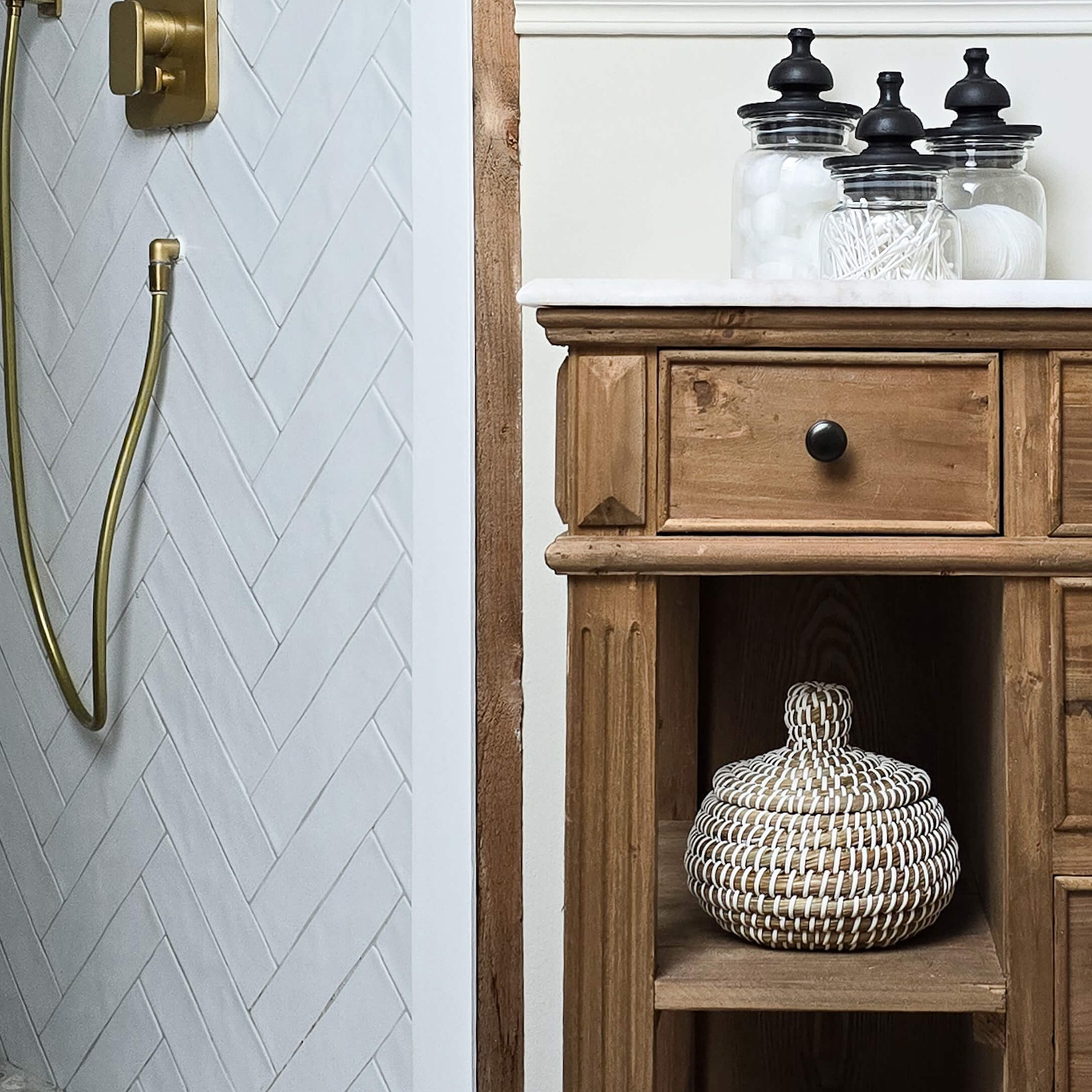 Rustikaler Holz-Badezimmerschrank mit weisser Arbeitsplatte und Glasbehältern für Accessoires