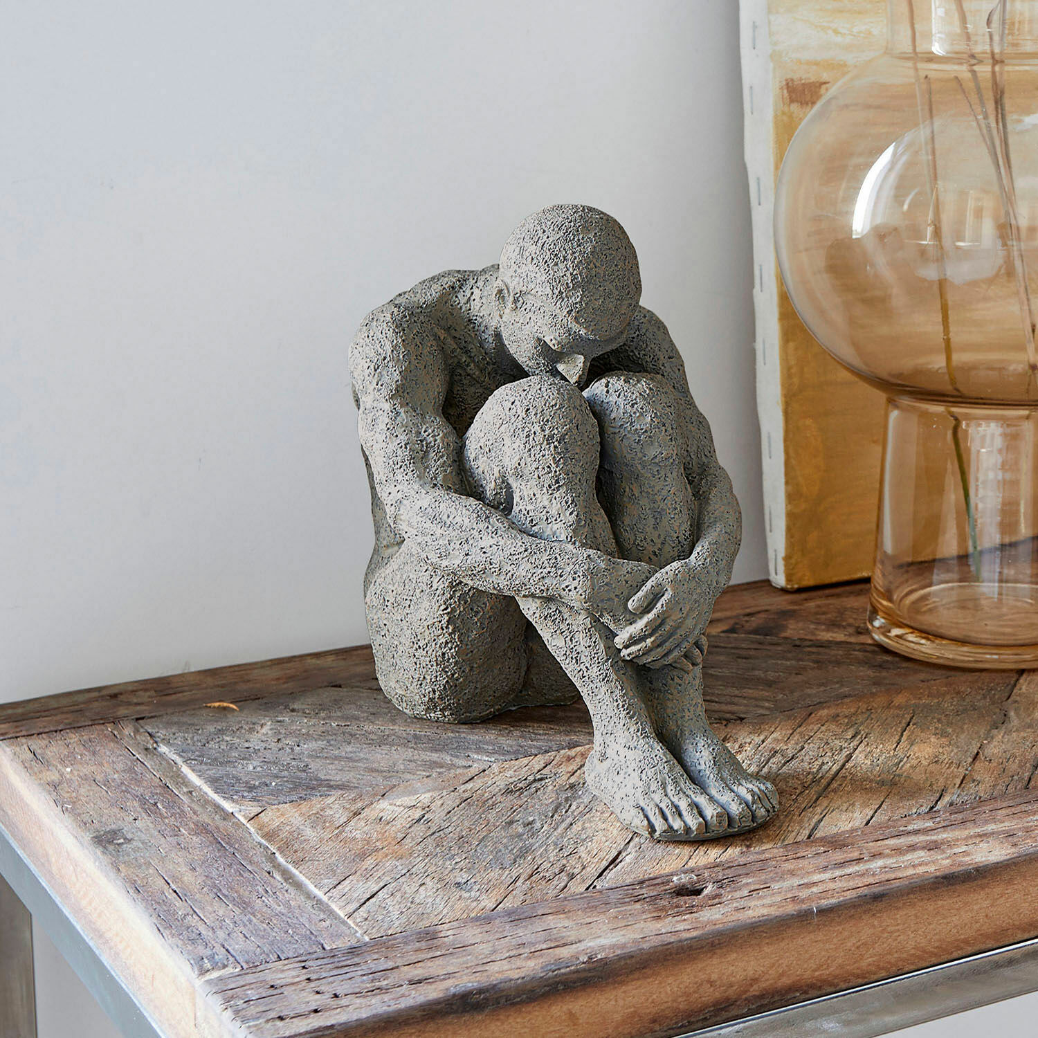 Figur Antony Graue Steinskulptur einer sitzenden Figur auf Holztisch, moderne Wohnraumdekoration