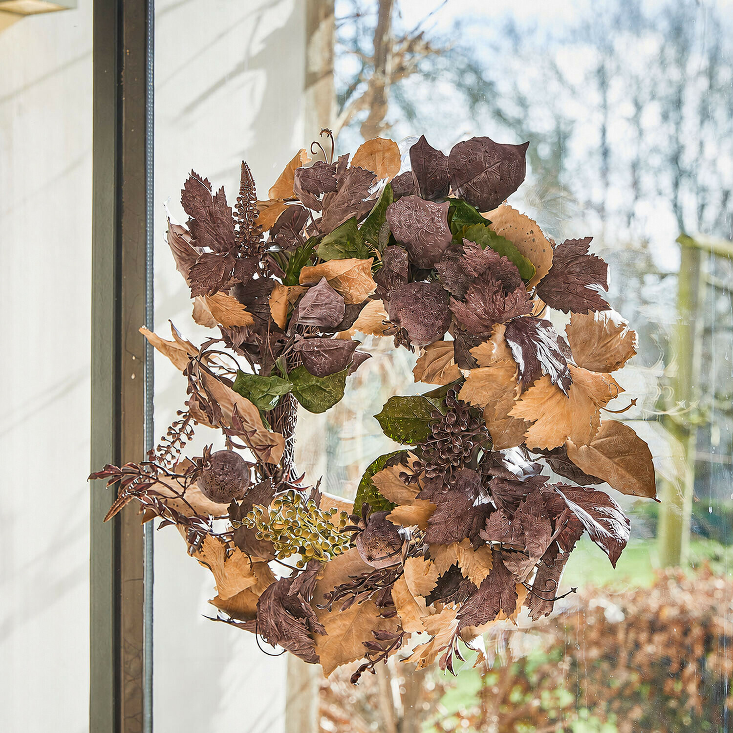 Kranz Yvorie Esszimmer mit rundem Holztisch und Rattanstühlen mit weissen Polstern und herbstlicher Dekoration