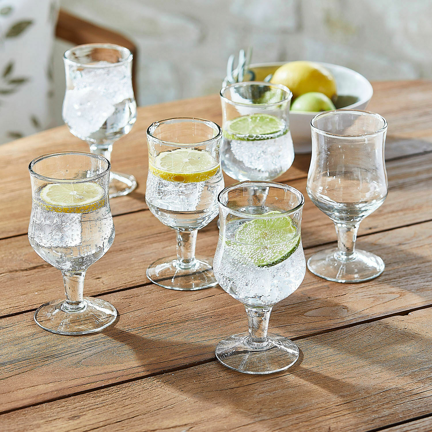 Glas 6er Set Gaëtane Sechsteiliges Set Gläser aus klarem Glas mit Zitronen- und Limettenscheiben auf Holztisch