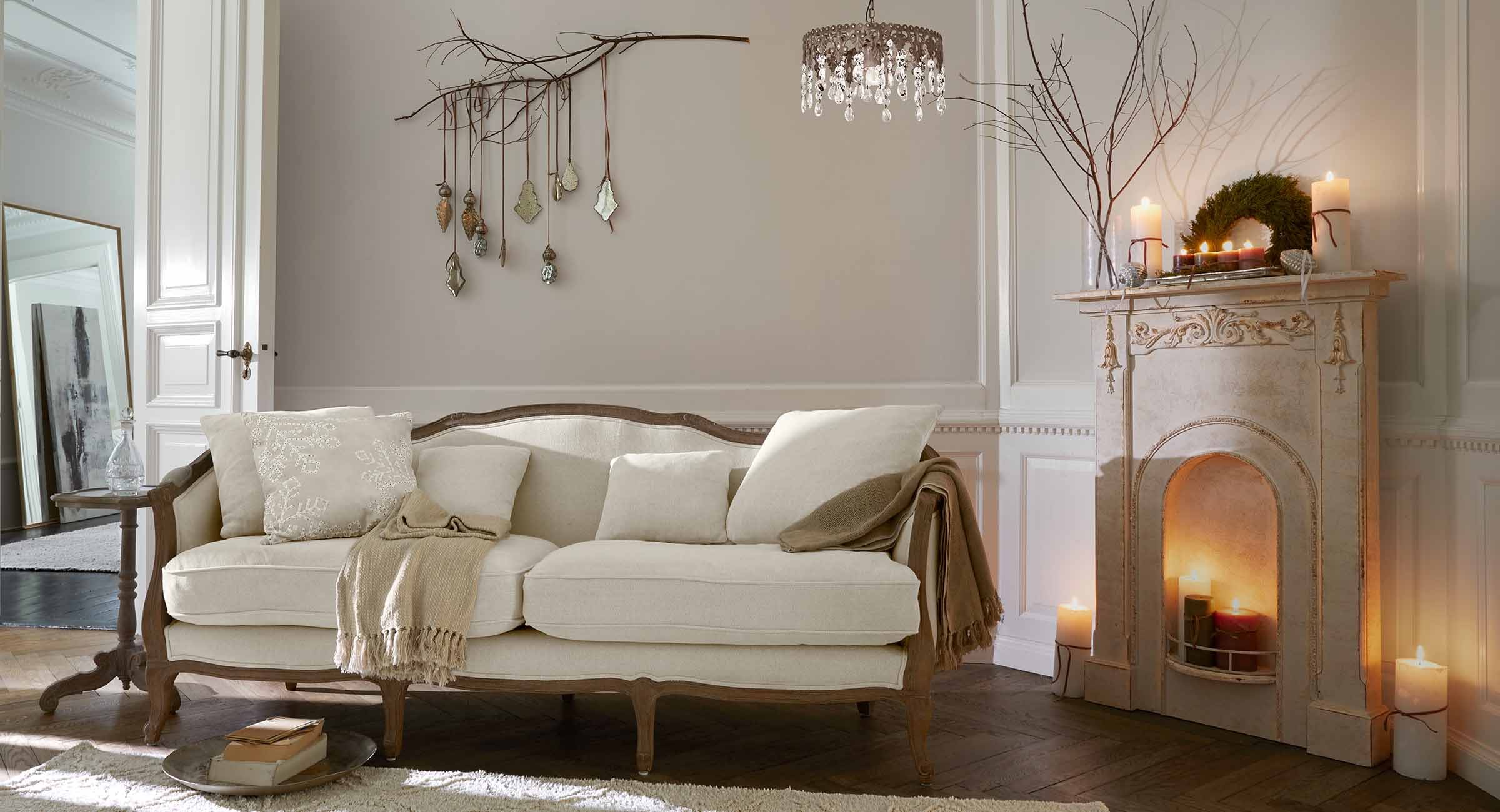 Beiges Sofa mit Holzrahmen in klassischem Wohnzimmer mit Cheminée und Wanddekorationen