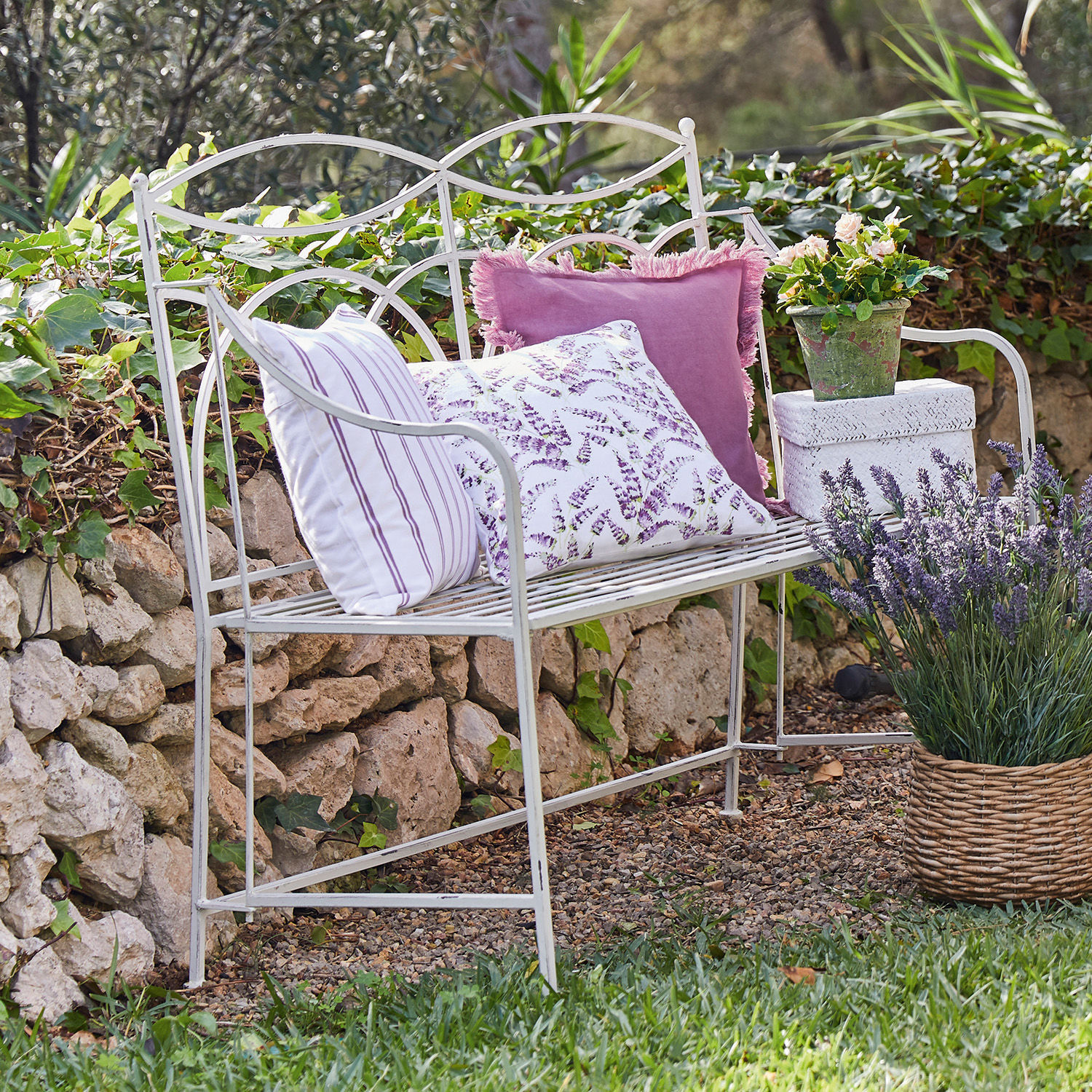 Bank Jablines Weisse Metall-Gartenbank mit violetten Kissen und Lavendel in einem Korb im Garten
