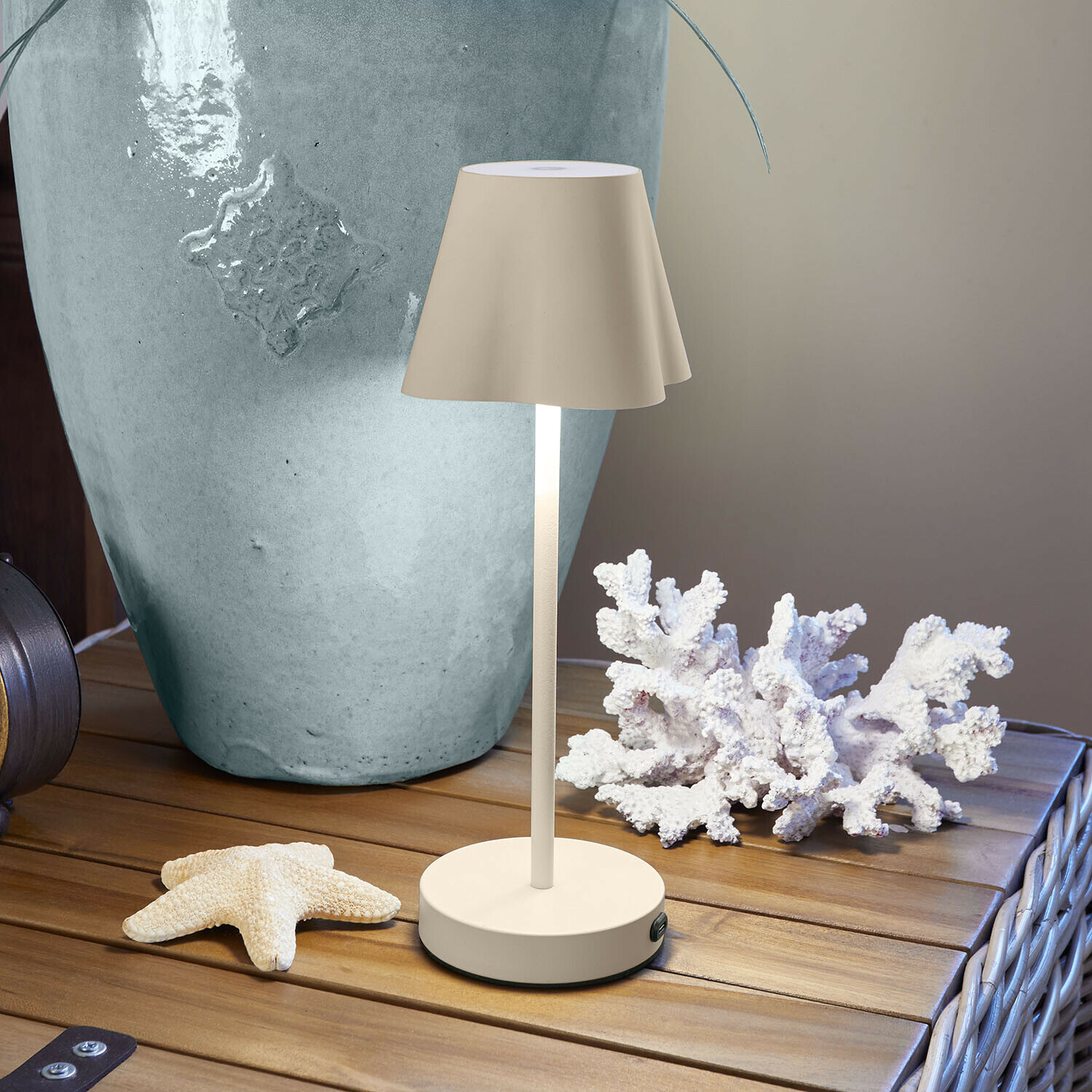 Wiederaufladbare Tischlampe Tenari Beige Metall-Tischlampe auf Holztisch mit maritimer Dekoration und grossem Vase