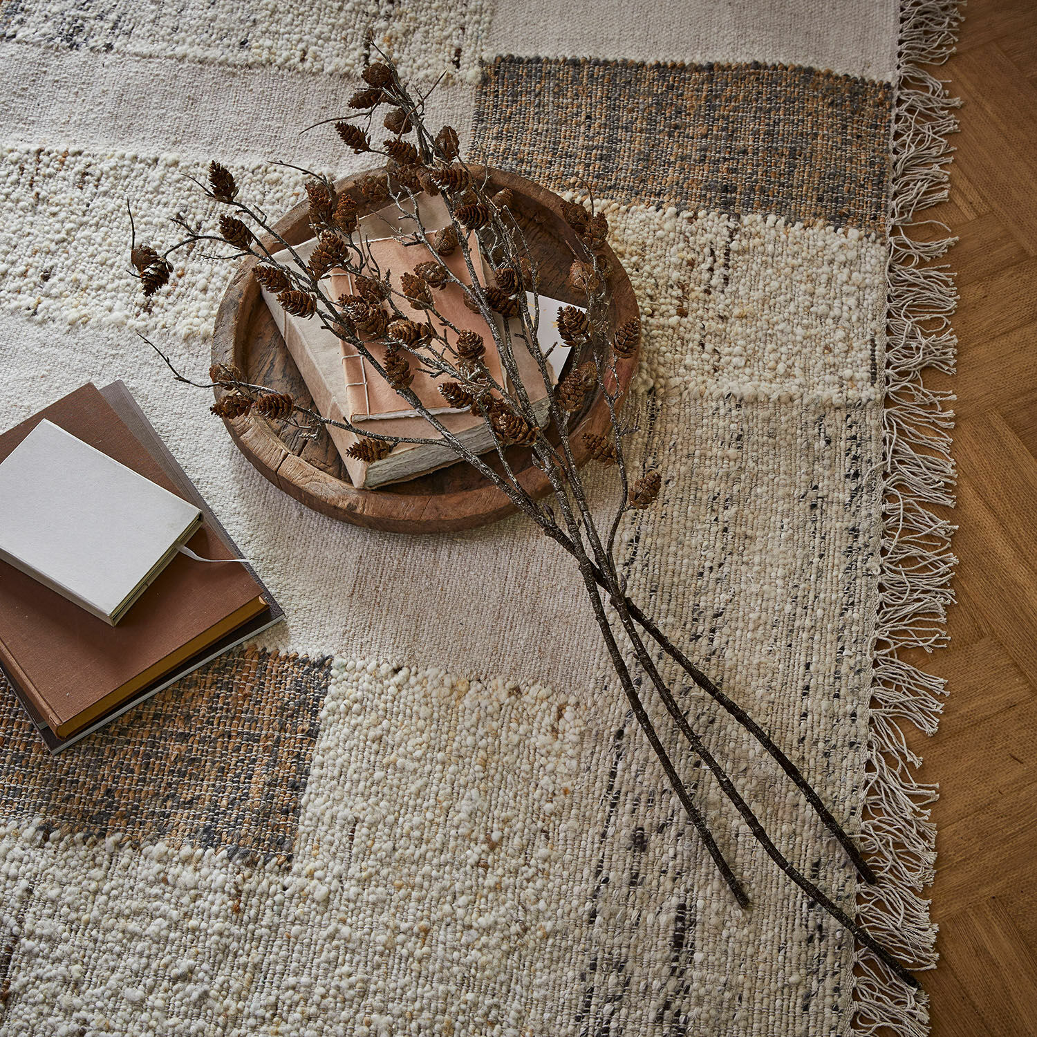 Deko-Ast 3er Set Eisvyn Naturwollteppich in Beige-Braun mit Fransen, dekoriert mit Büchern und Zweigen