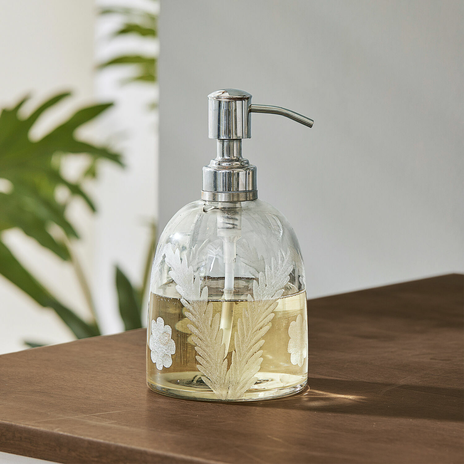 Seifenspender Crystal Glas-Seifenspender mit Metallpumpe und weissem Blattmuster auf braunem Holztisch