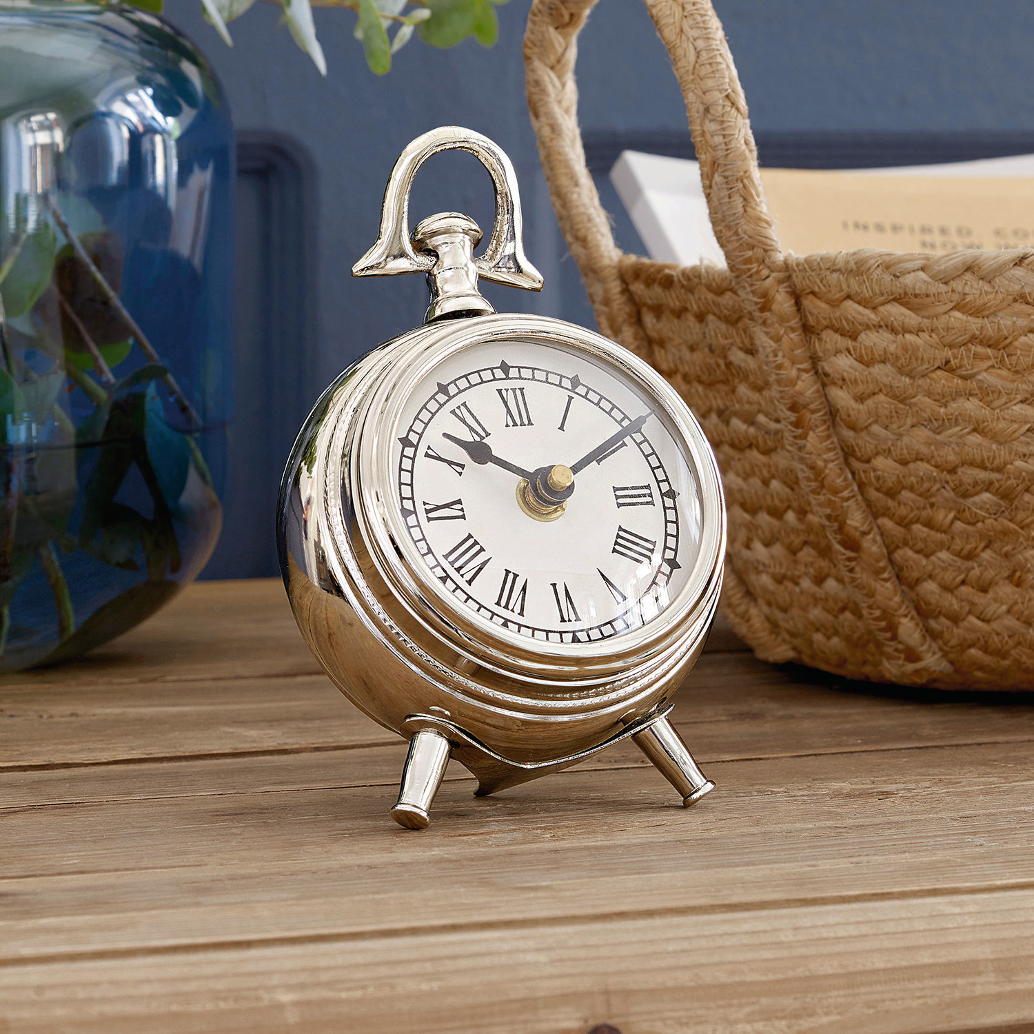 Uhr Coraten Silberne Metall-Tischuhr mit römischen Ziffern auf Holzuntergrund, stilvolles Wohnaccessoire