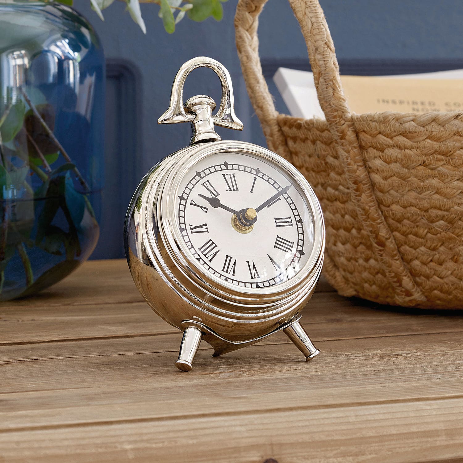 Uhr Coraten Silberne Metall-Tischuhr mit römischen Ziffern auf Holzuntergrund, stilvolles Wohnaccessoire