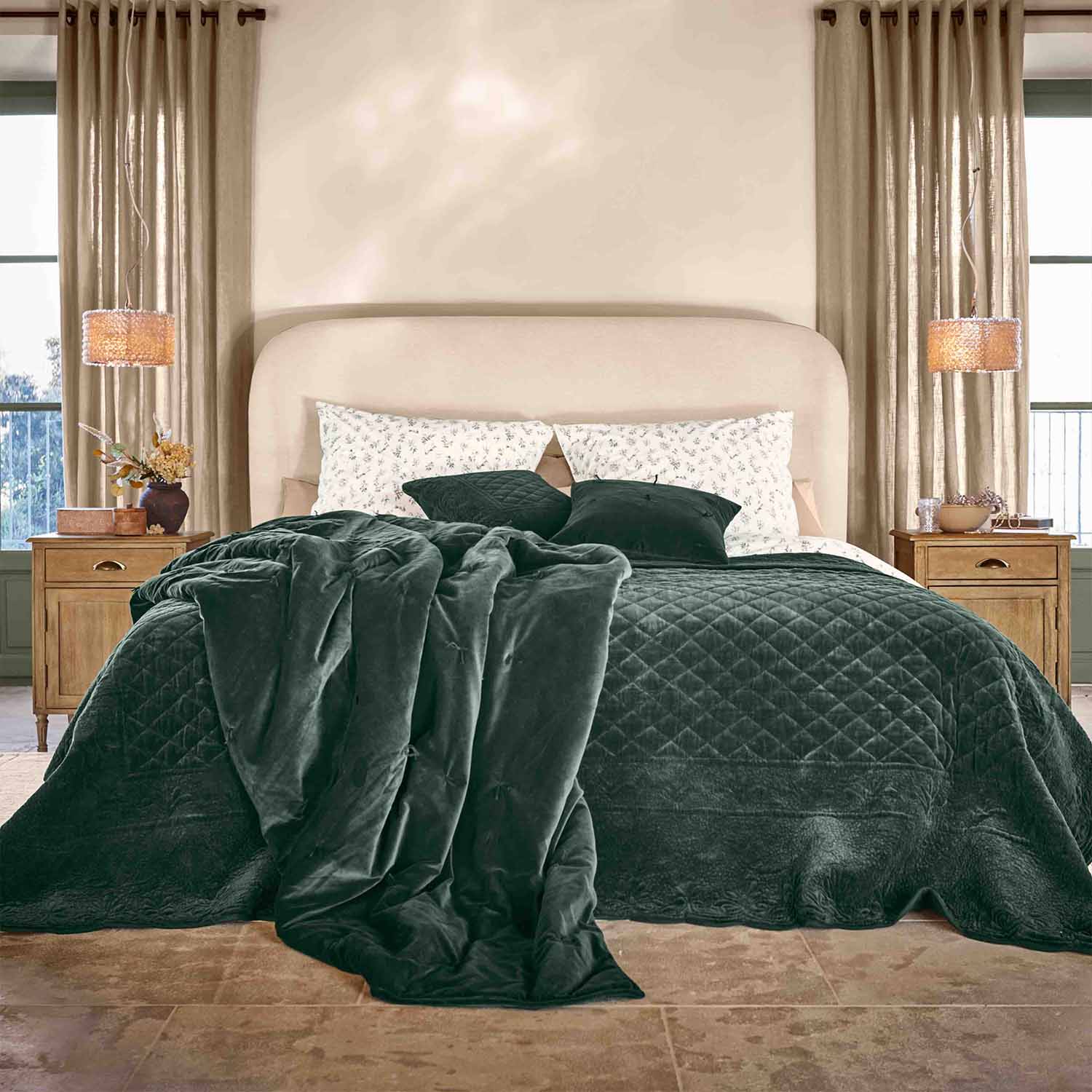 Dunkelgrüne Samtdecke und Kissen auf Bett mit beigem Kopfteil in gemütlichem Schlafzimmer