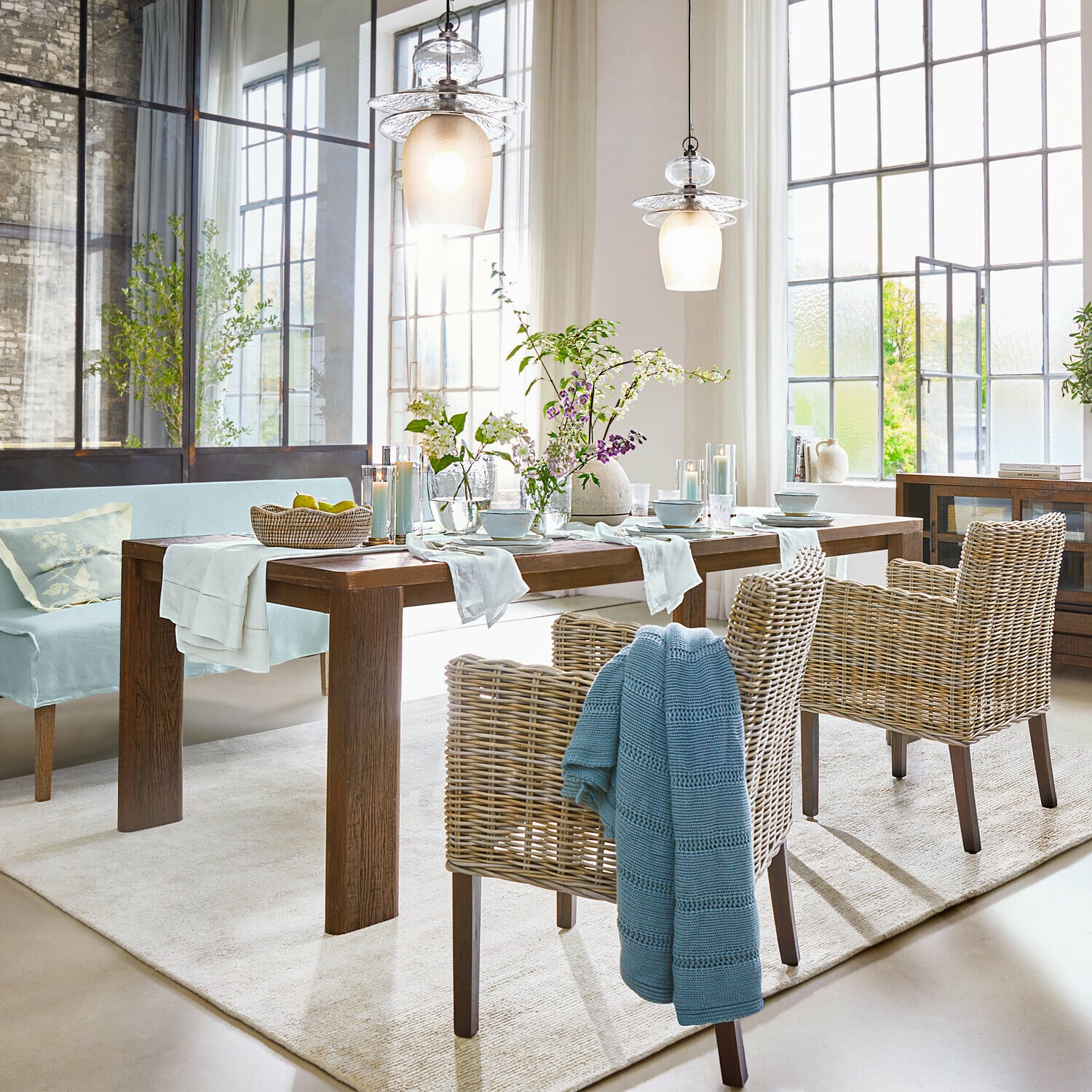 Tisch Gianoro Esszimmer mit Holztisch, Rattanstühlen und rustikaler Dekorbeleuchtung