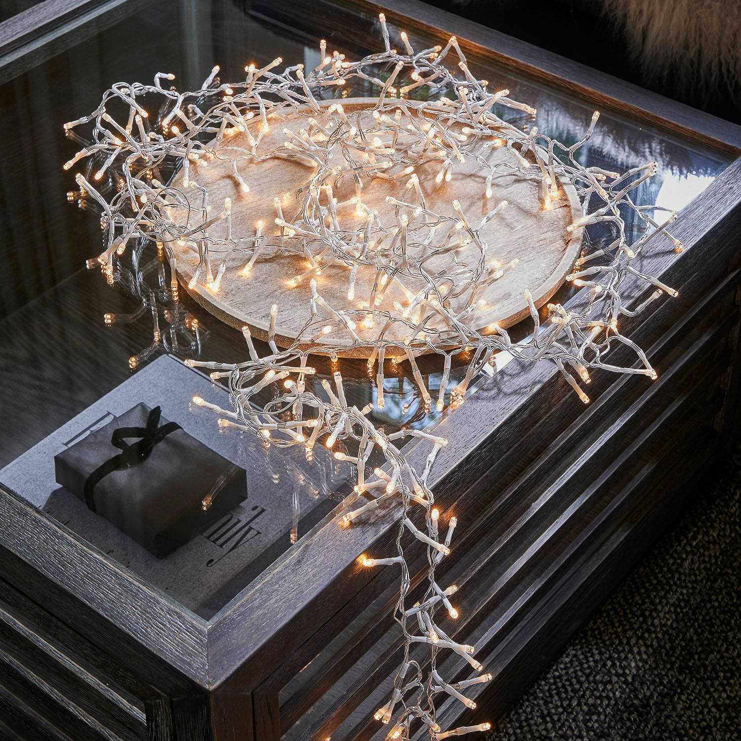 Lichterkette Aedara LED-Lichterkette mit warmweißem Licht auf transparentem Kabel auf Holztablett auf Glastisch