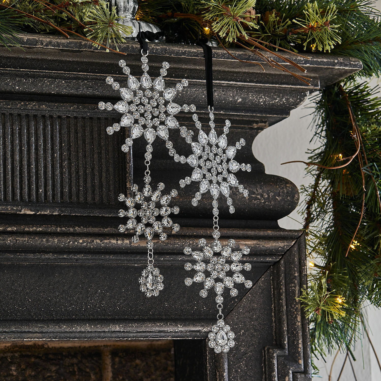 Weihnachtsanhänger 2er Set Klerven Weihnachtliche Dekoration aus transparenten Kristallen in Schneeflockenform am schwarzen Kamin mit grünen Zweigen