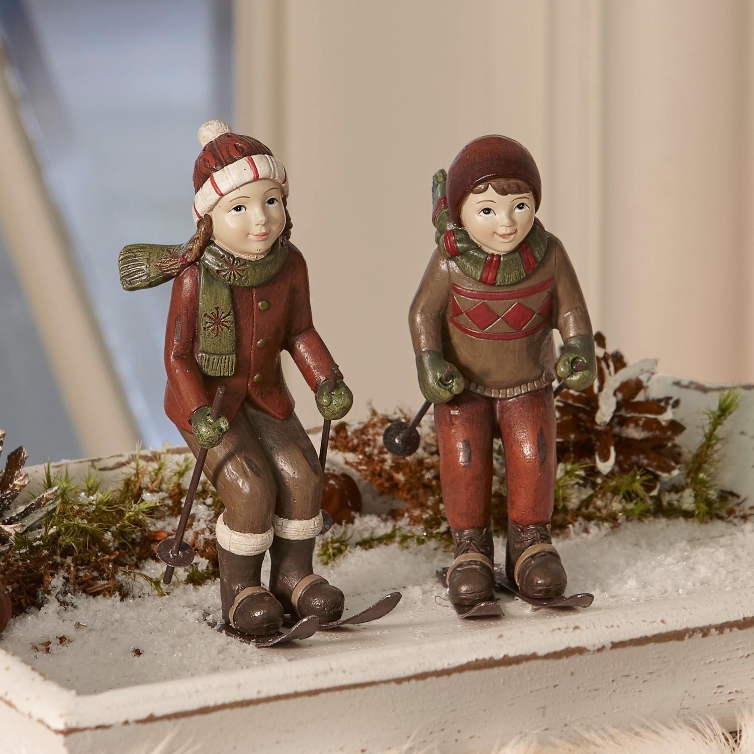 Figur 2er Set Bibury Figuren von Kindern in braun-roter Kleidung beim Skifahren als winterliche Weihnachtsdekoration