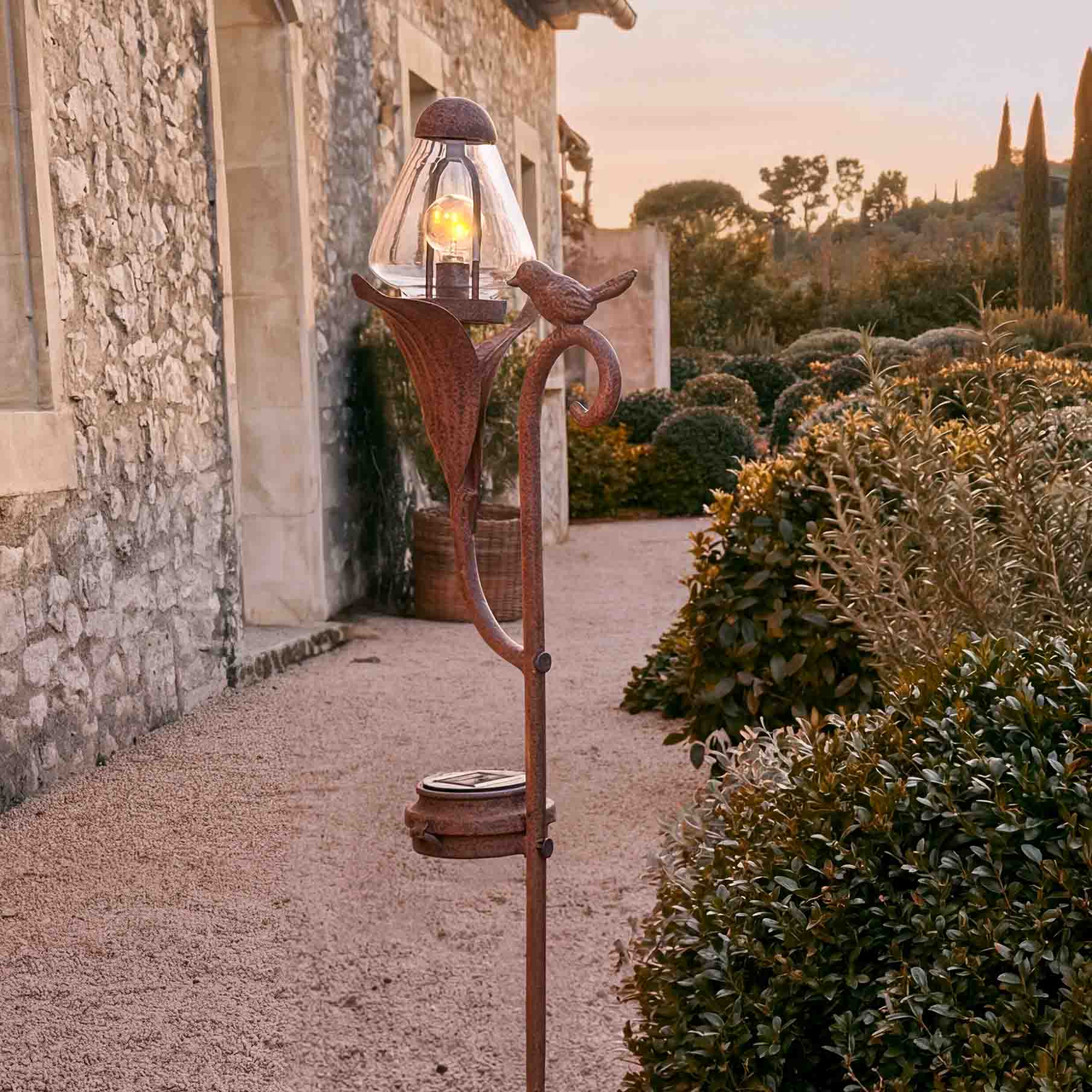 Dekorative Gartenlampe aus rostigem Metall mit Glasabdeckung und Vogelmotiv
