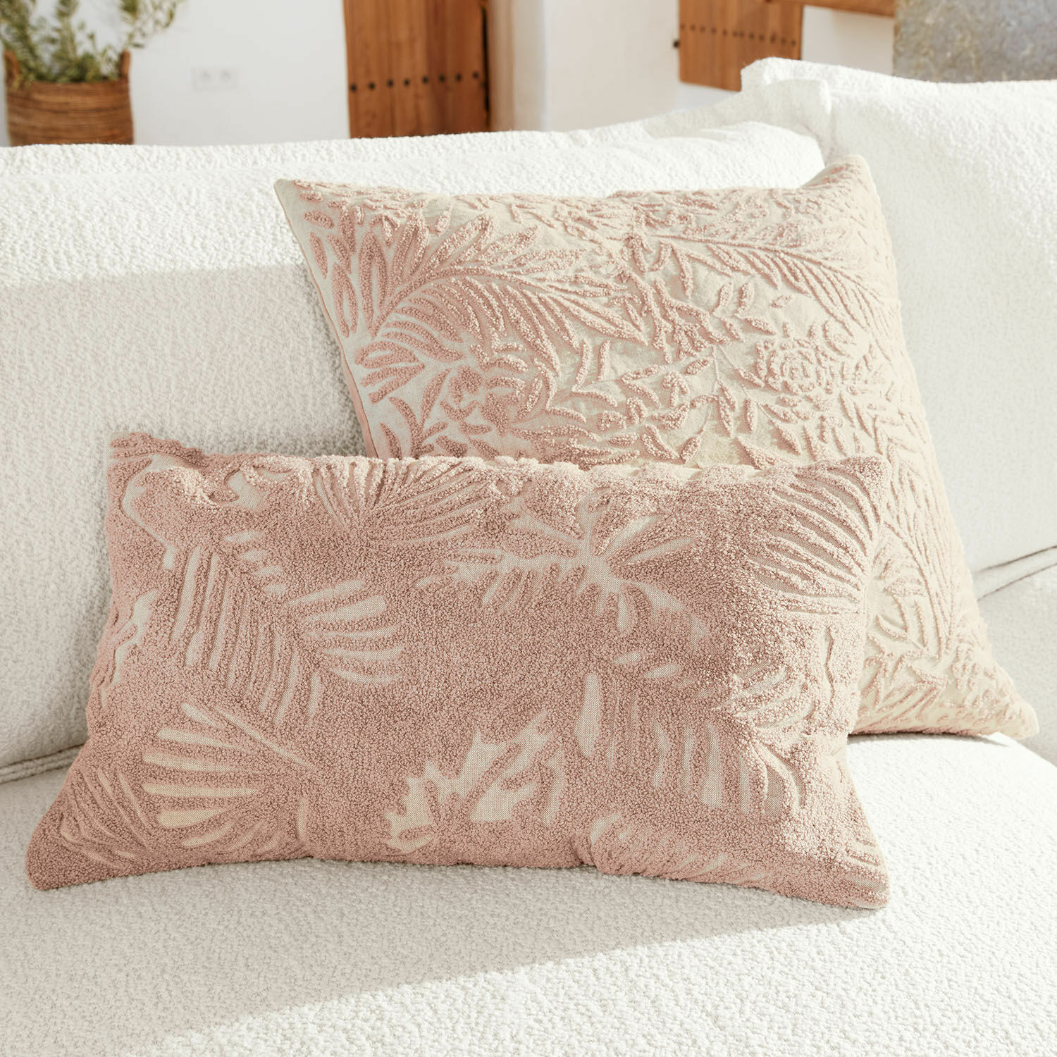 Kissenhülle 2er Set Enchanto Zwei dekorative Kissen mit rosafarbenem Blattmuster auf cremefarbenem Grund auf weissem Sofa
