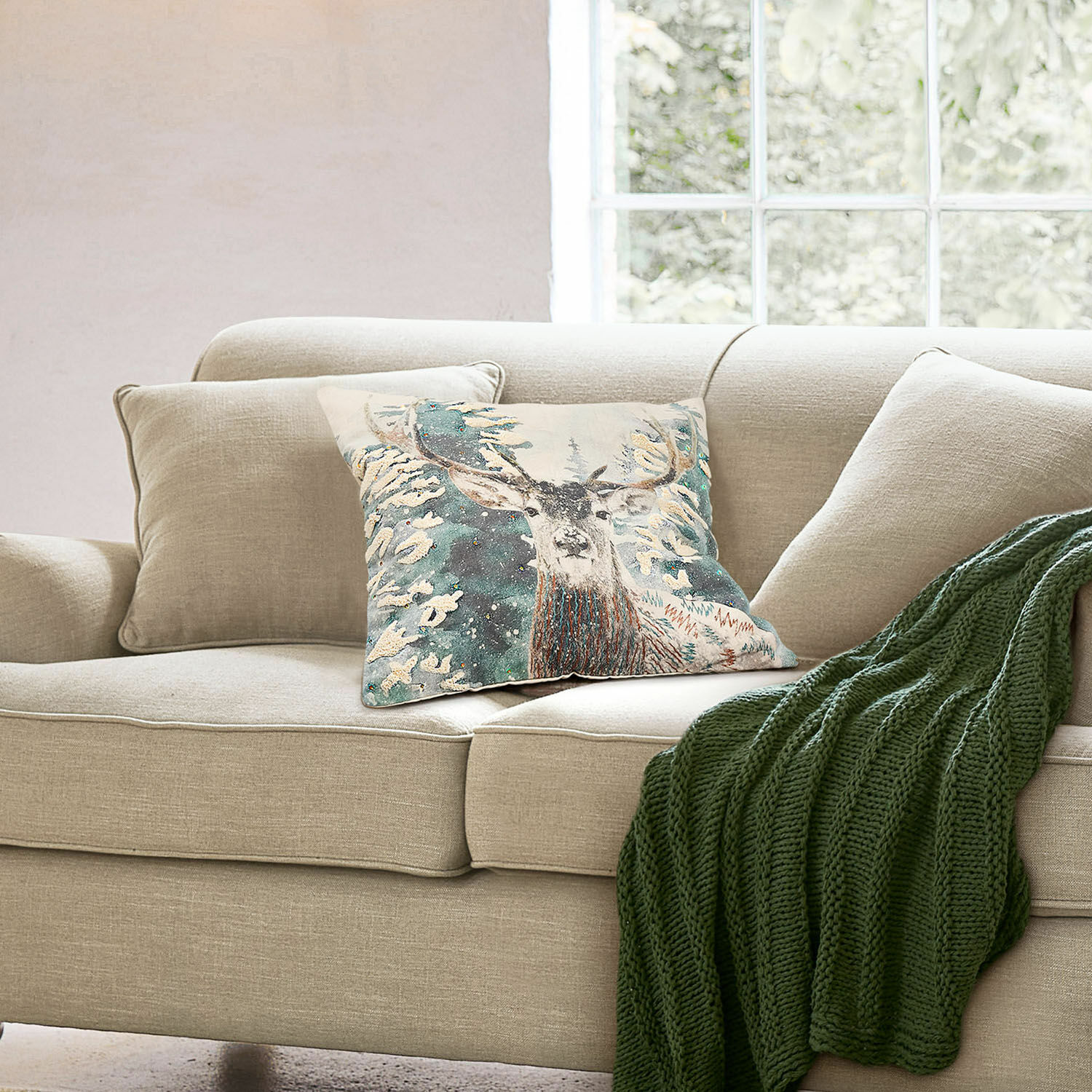 Kissenhülle Elvaris Beiges Sofa mit dekorativem Hirschkissen und grünem Strickplaid in hellem Wohnzimmer