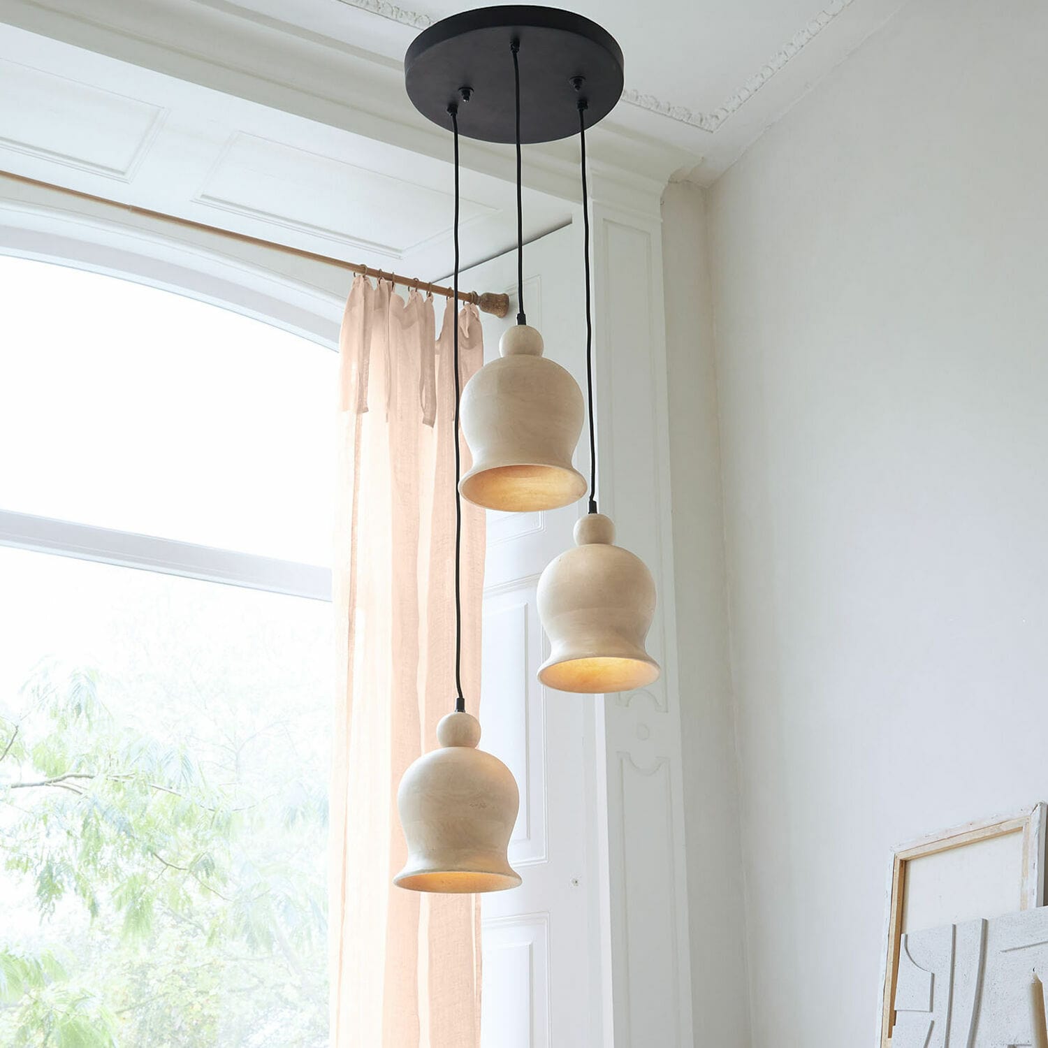 Hängelampe Ziravet Drei hängende Lampen aus hellem Holz mit organischer Form in einem hellen Raum mit grossem Fenster