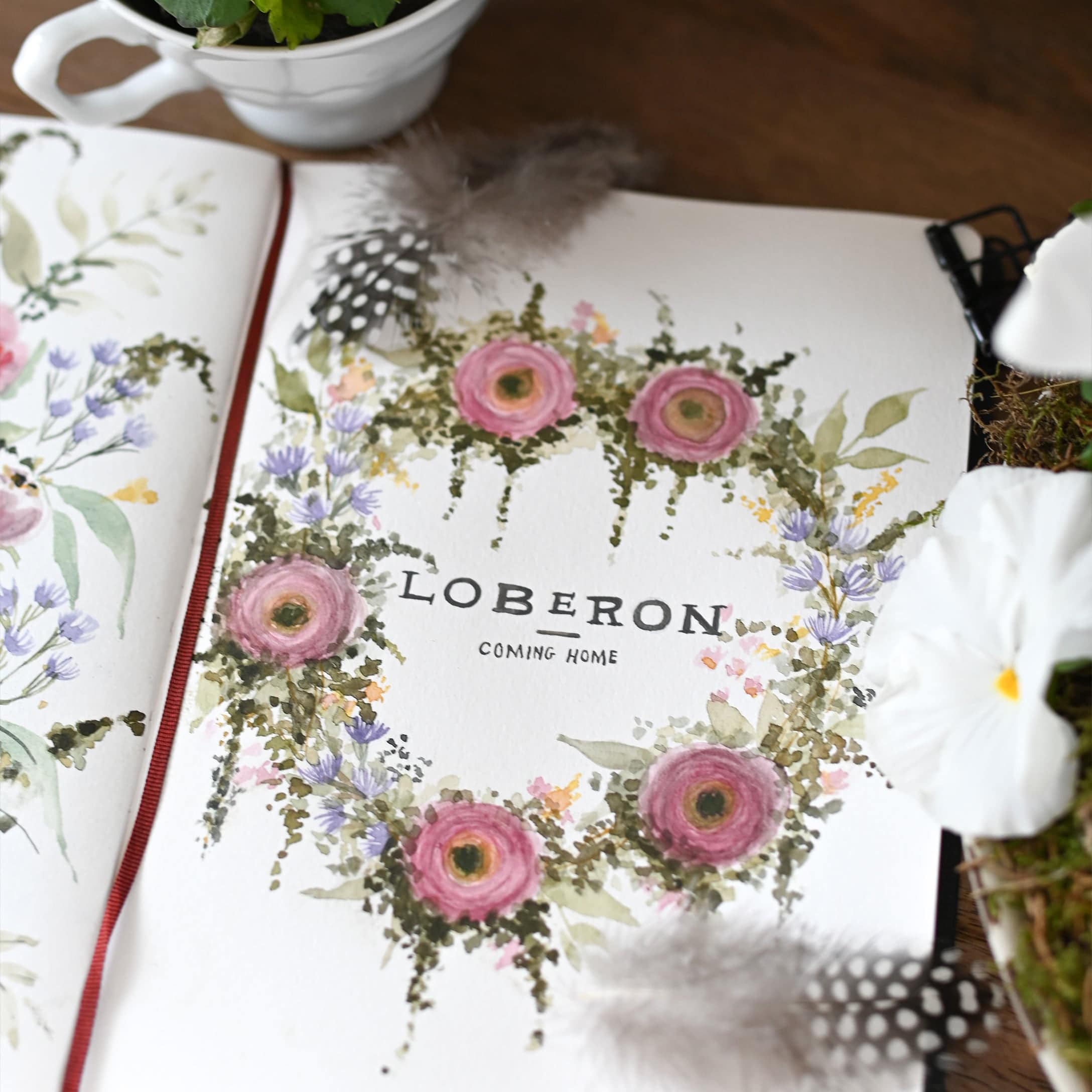 Aquarellierter Blumenkranz mit rosa und violetten Blüten, Federn und weissen Blumen auf Papier