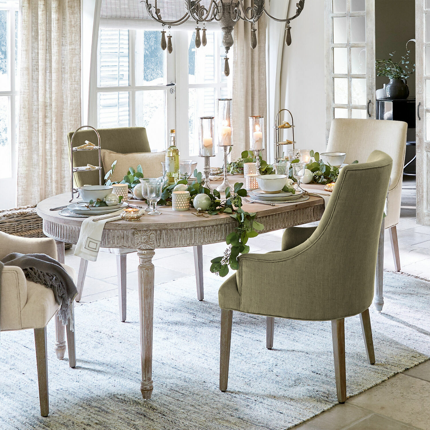 Tisch Cienegas Esszimmer mit ovalem Holztisch und grünen sowie beigen Polsterstühlen, festliche Dekoration