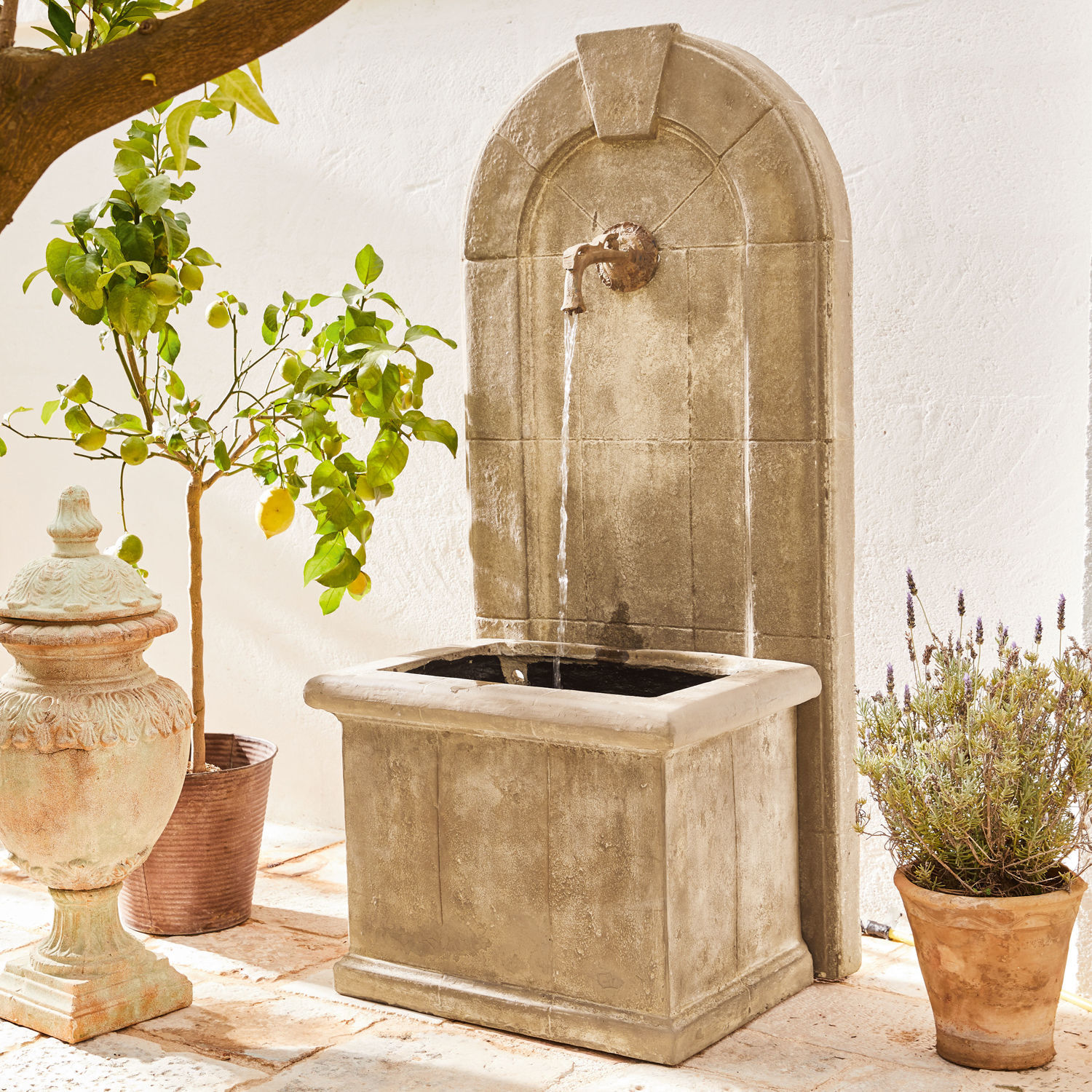 Brunnen Ginette Dekorativer Gartenbrunnen aus beigem Stein mit Metallhahn und fliessendem Wasserstrahl