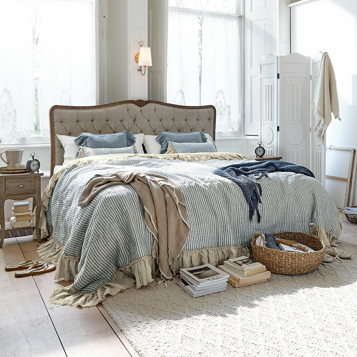 Quilt Alexane Gemütliches Schlafzimmer mit beige gepolstertem Bett und blau-weiss gestreifter Bettwäsche