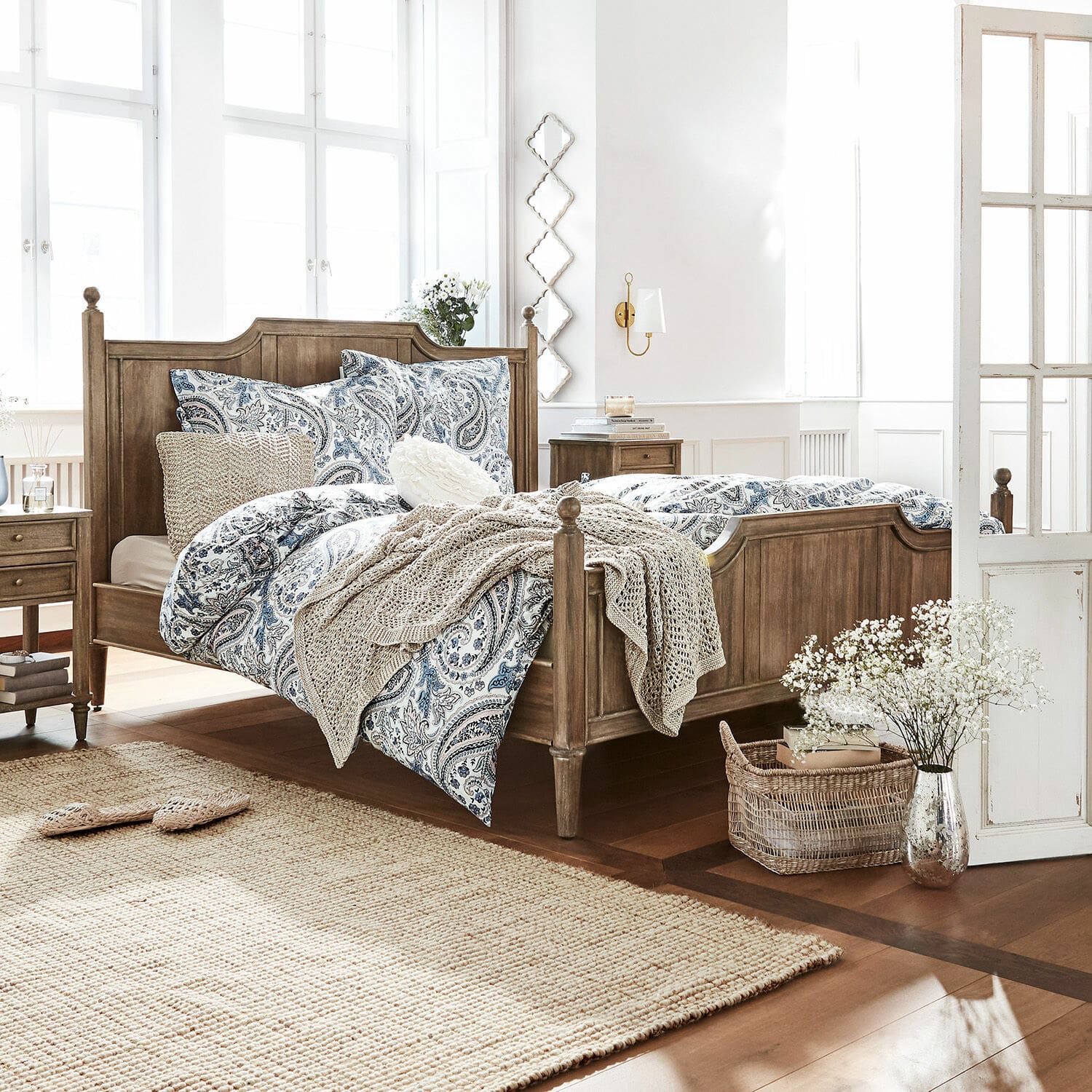 Bett Lubbock Schlafzimmer mit Holzbett und blau-weisser Paisley-Bettwäsche, Naturteppich und Dekorationen
