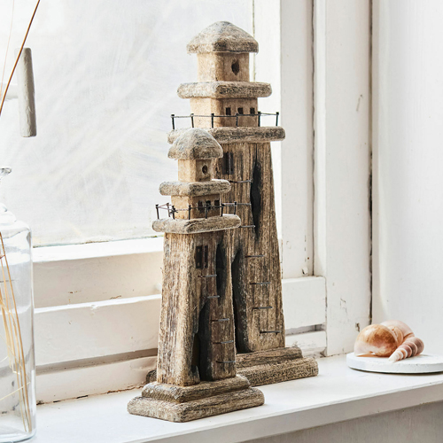 Zwei dekorative Leuchttürme aus Holz in Naturfarbe auf der Fensterbank, Wohnaccessoire